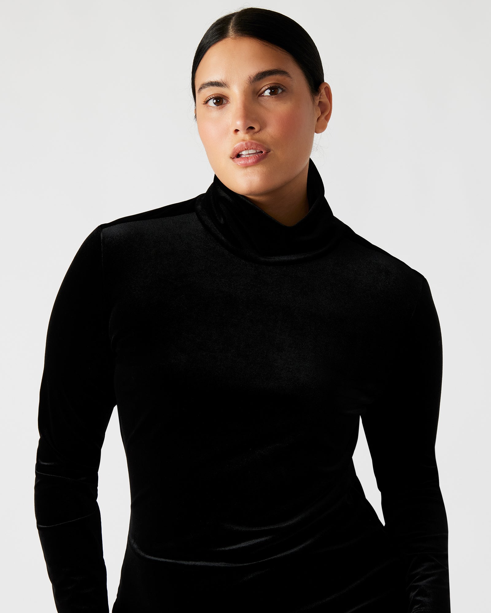 Side angle of the black mini dress highlighting the open back design.