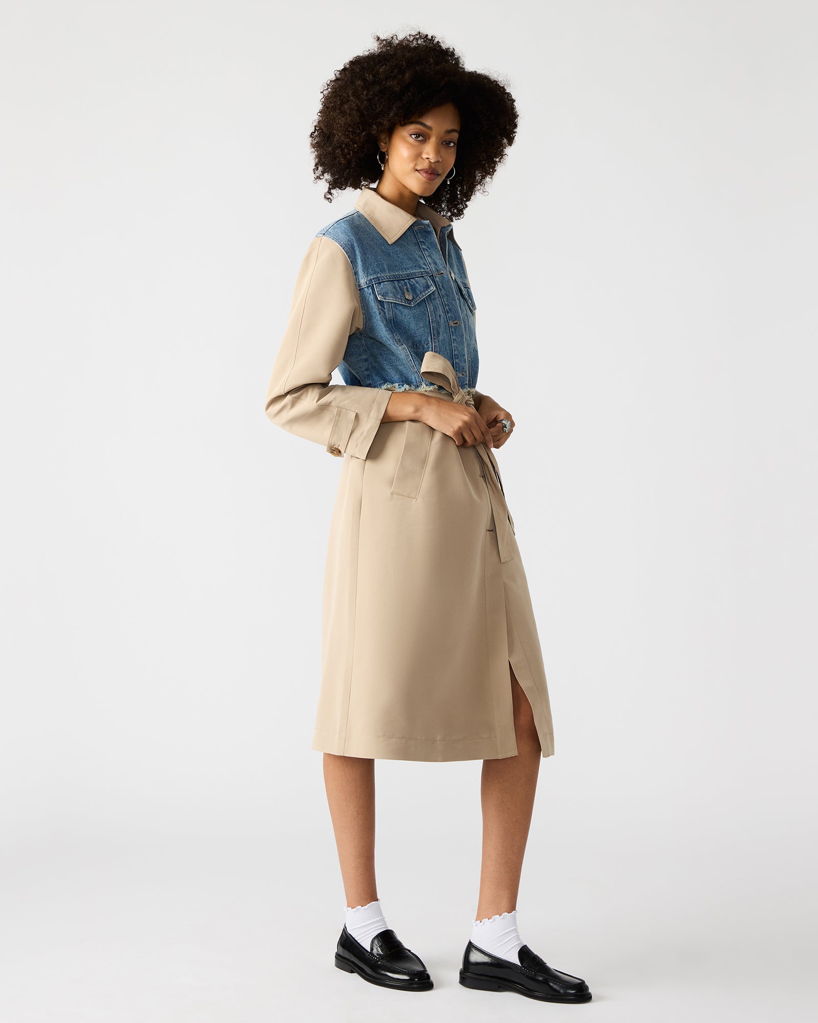 Back view of womens outerwear coat highlighting denim patchwork and button detail.