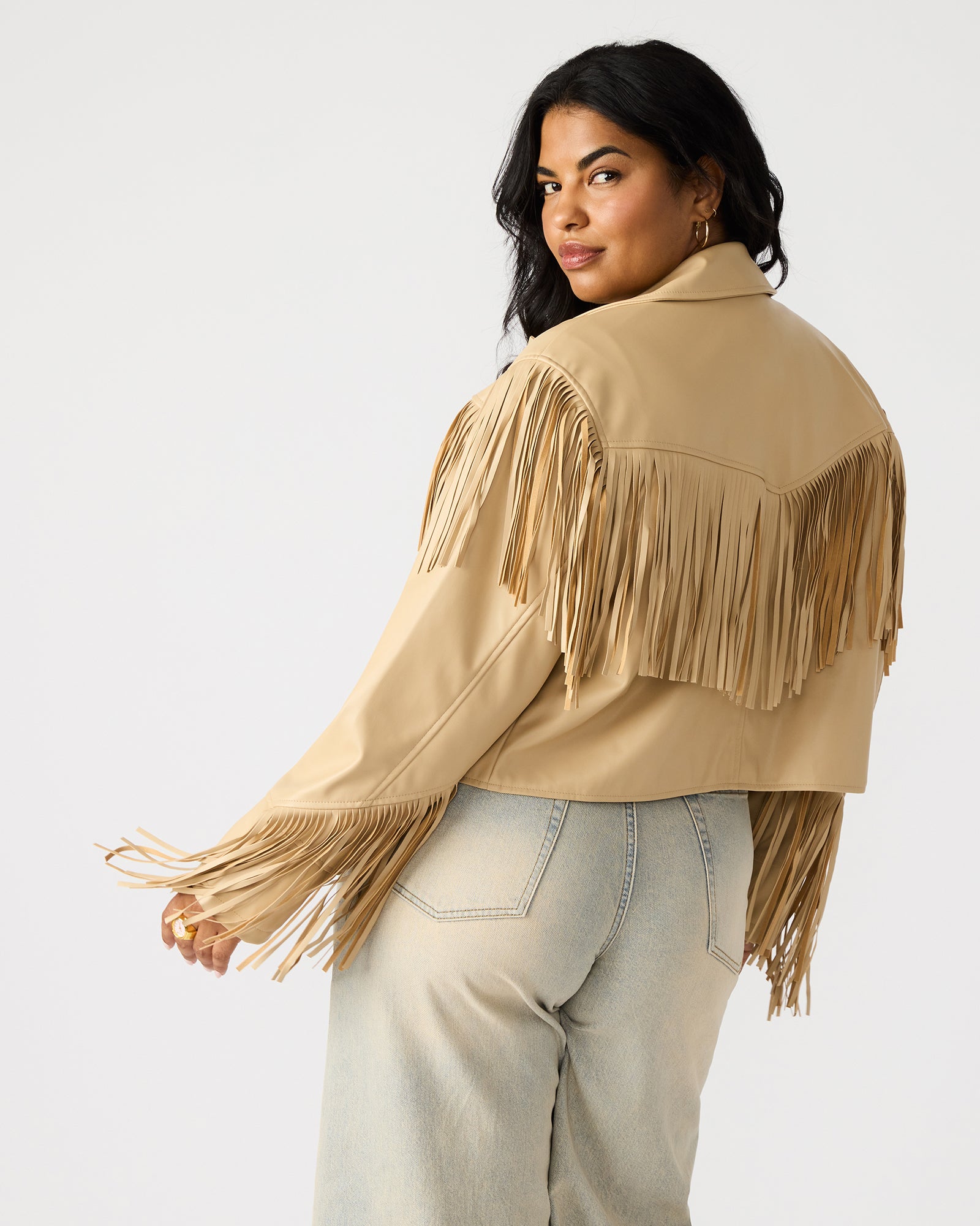 Front view of tan Western style jacket with fringe, worn by model against desert backdrop.