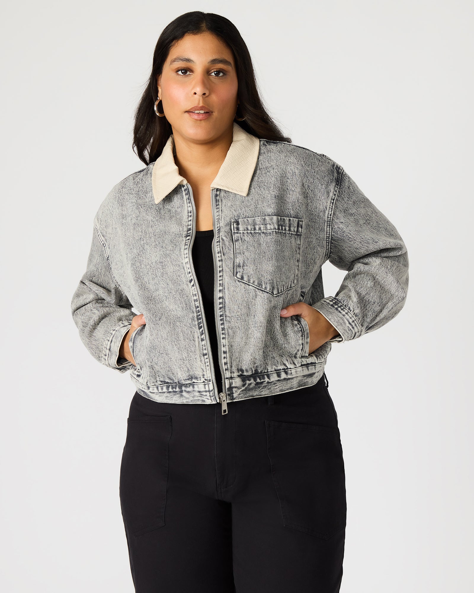 Front view of a woman in a light grey oversized denim jacket.