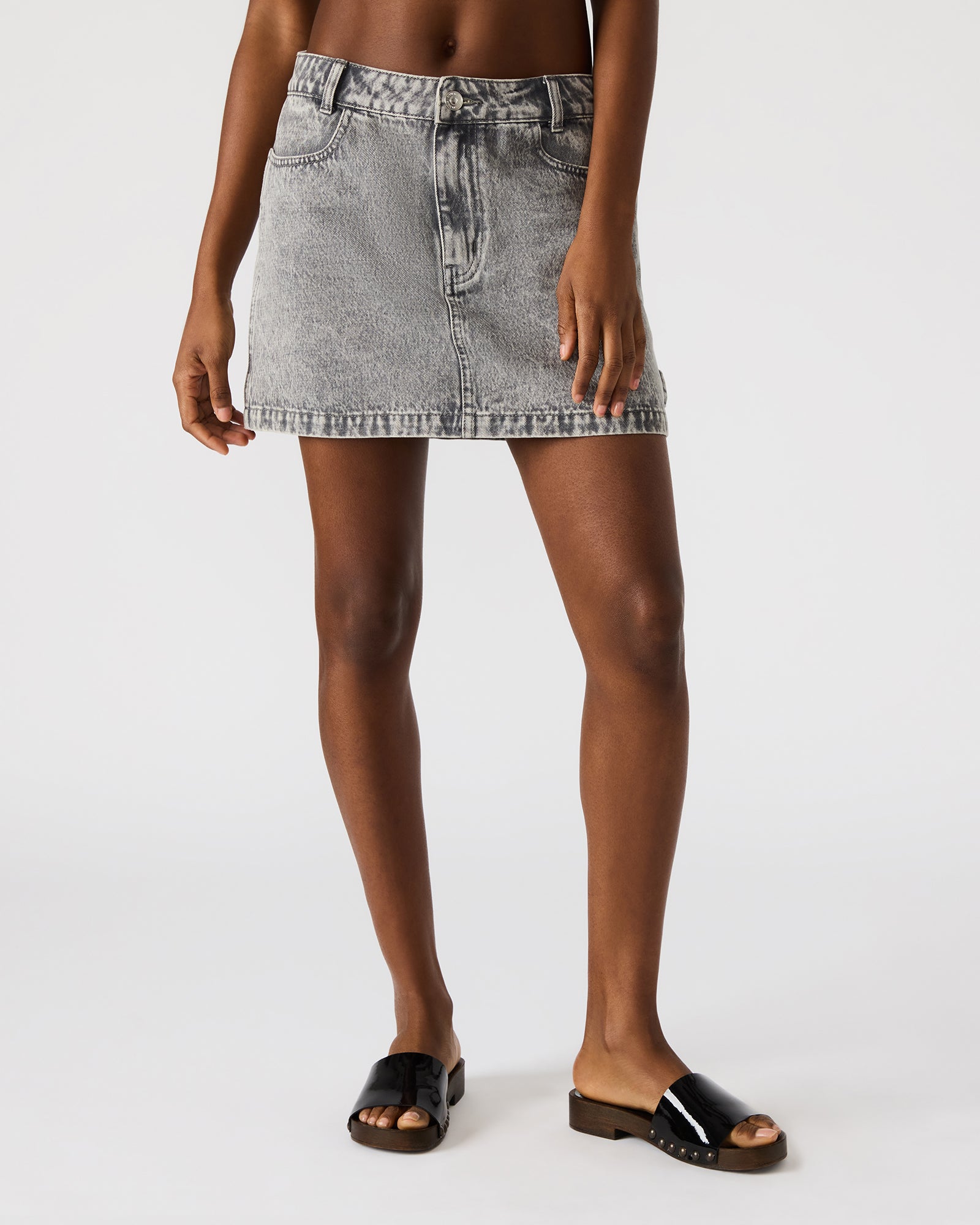 Side angle of the ABACO denim skirt worn with a casual top.