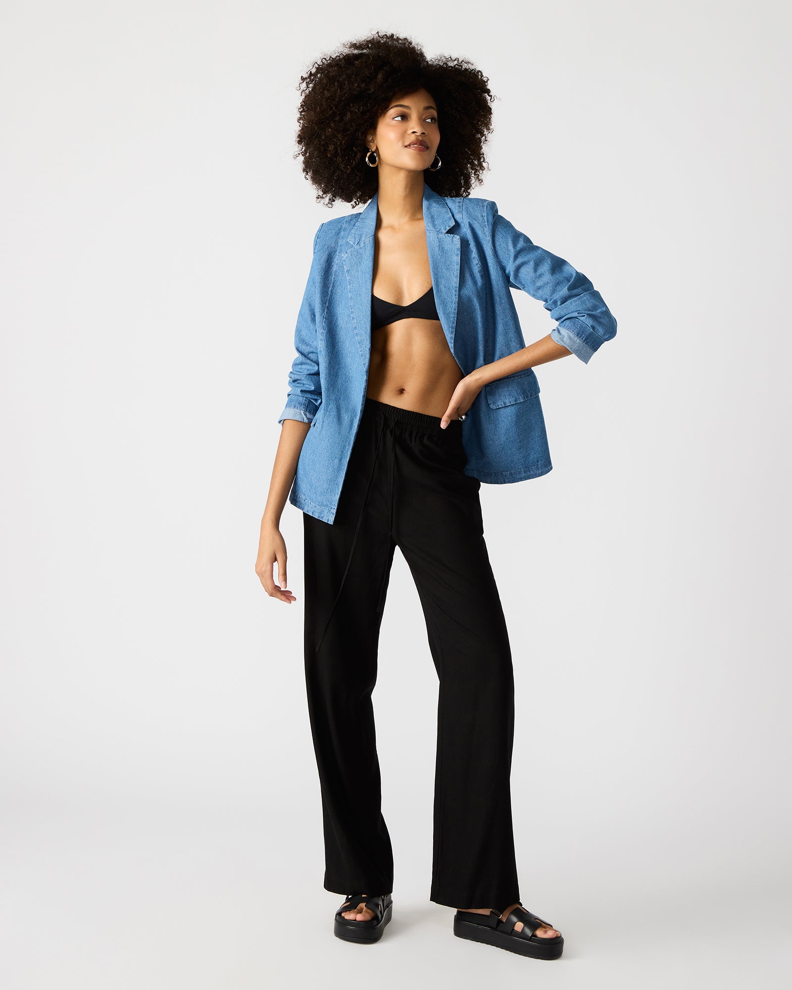 Detail shot of notched lapel and flap pockets on womens denim blazer