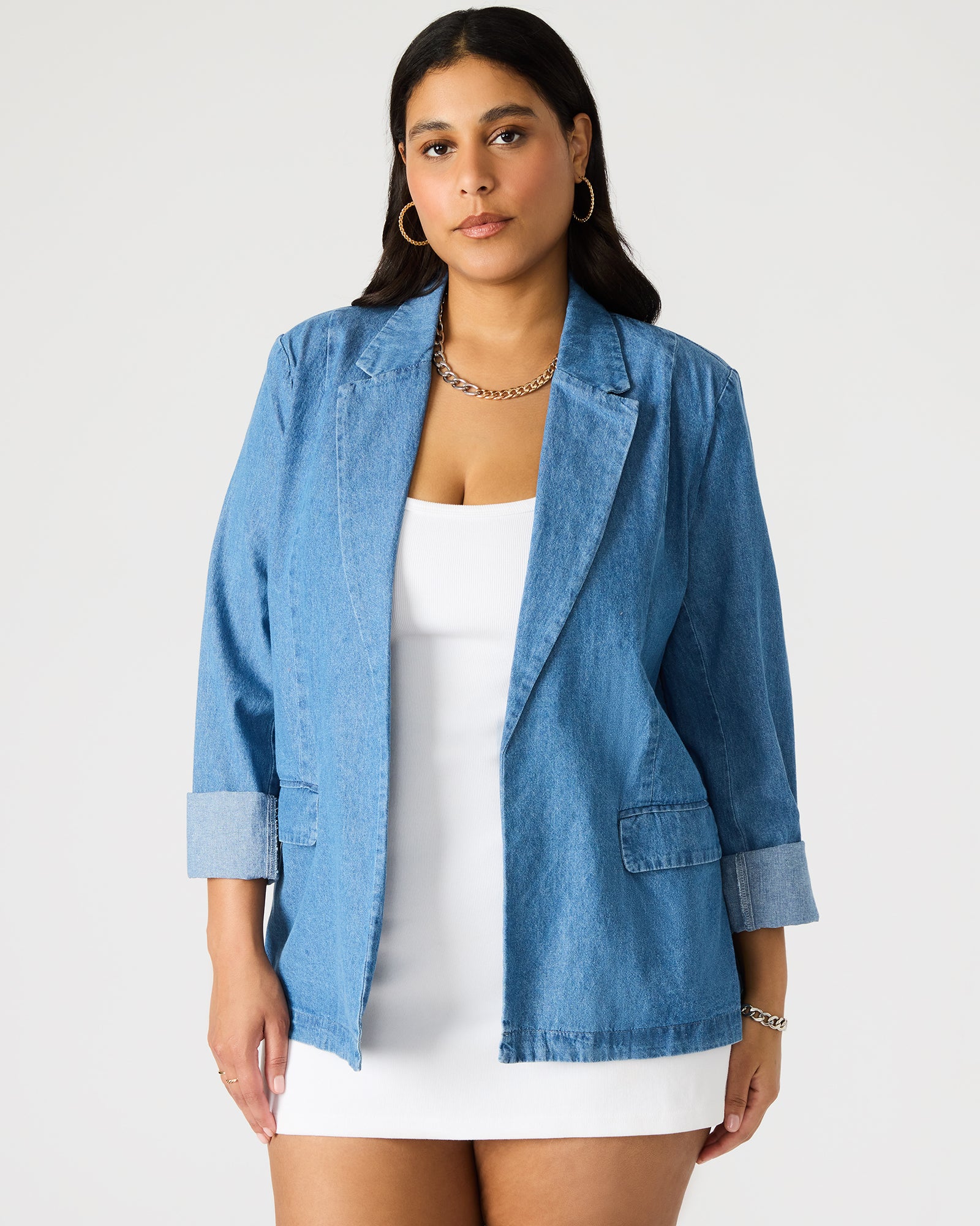 Front view of denim blazer women styled over white tee and trousers