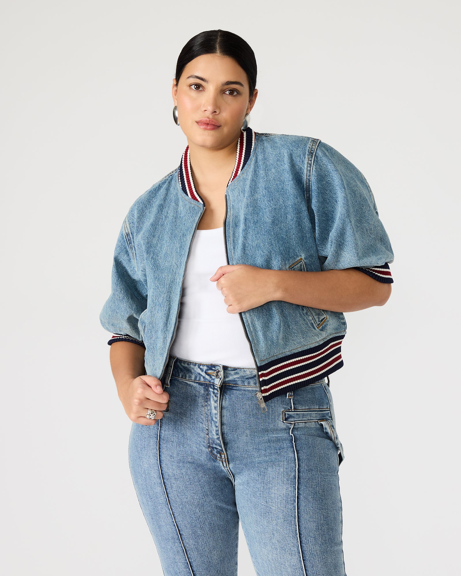 Front view of cropped puff sleeve jacket worn with black jeans on city sidewalk