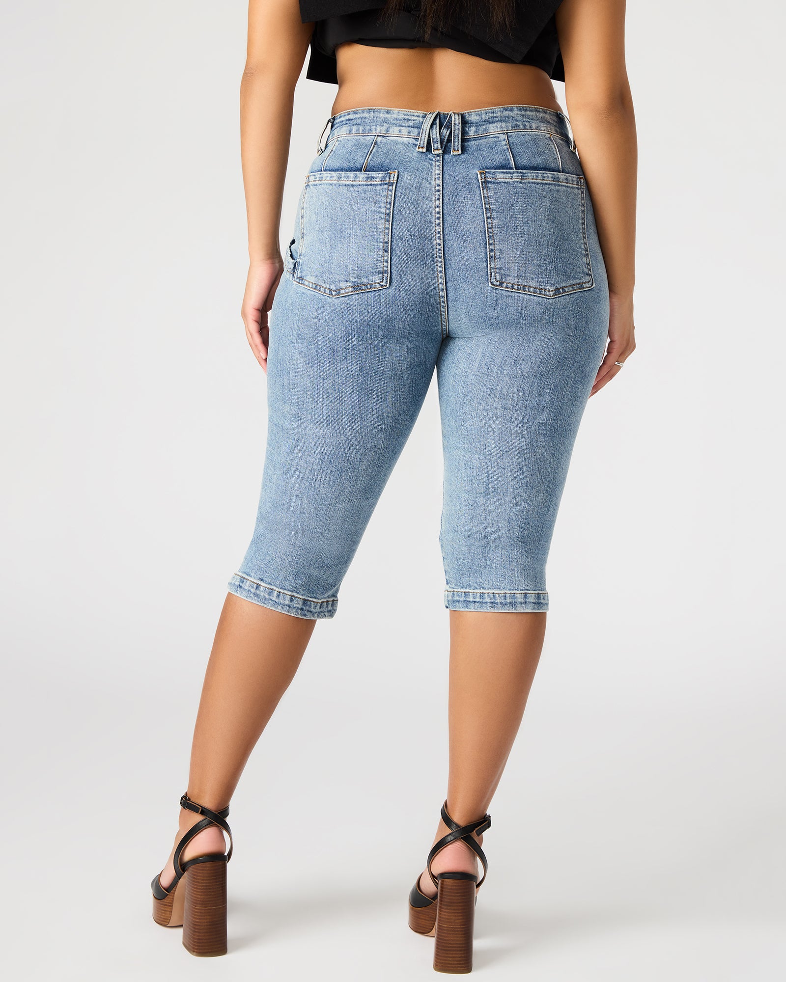Model wearing Delray Womens Skinny Denim Capri Pants in a casual setting.