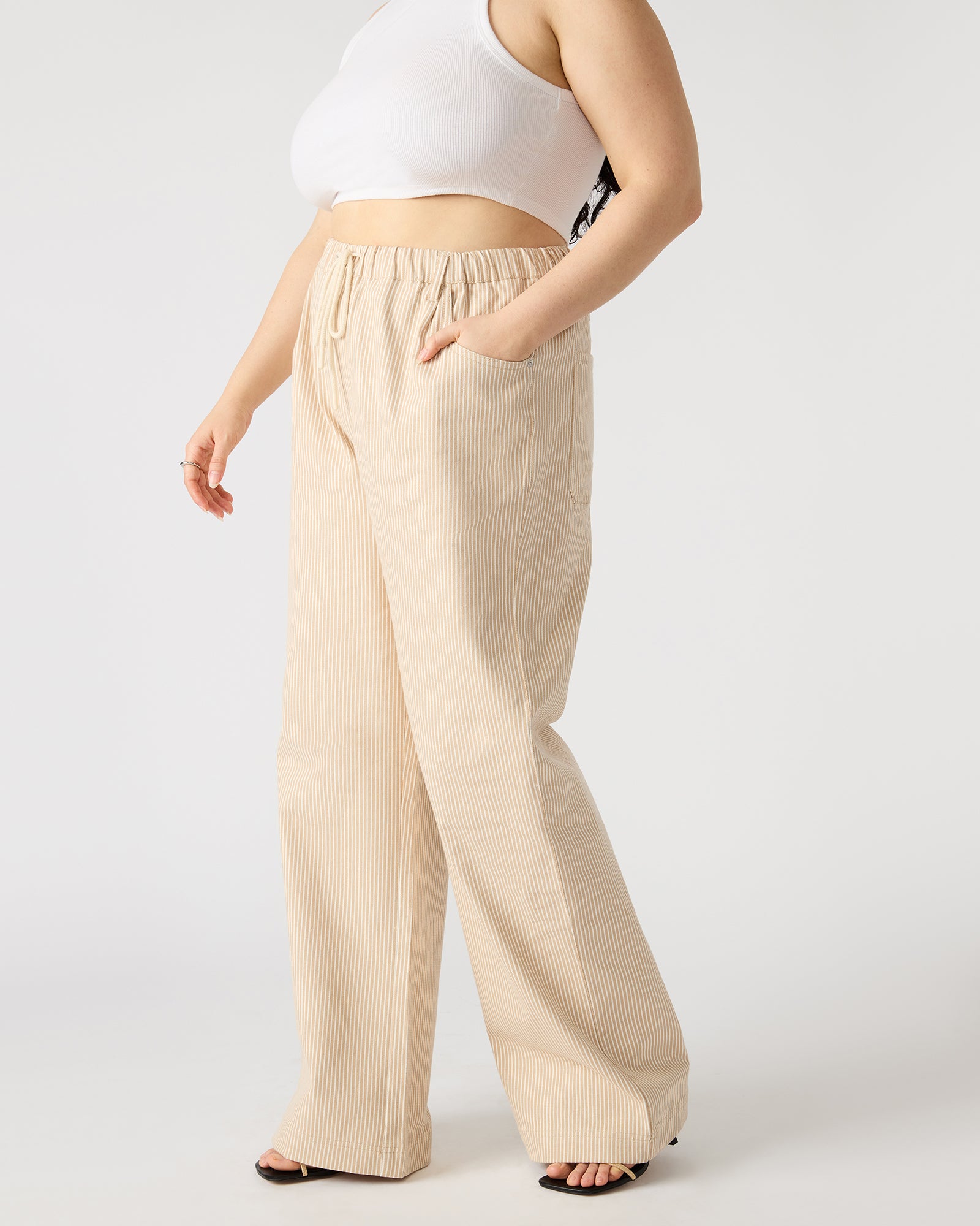 Front view of khaki cotton pants styled with sandals for warm weather days
