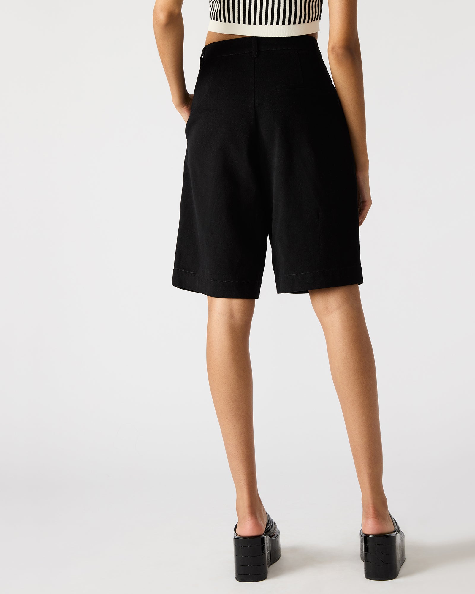 Model wearing mens black cotton shorts outdoors, highlighting comfort and style