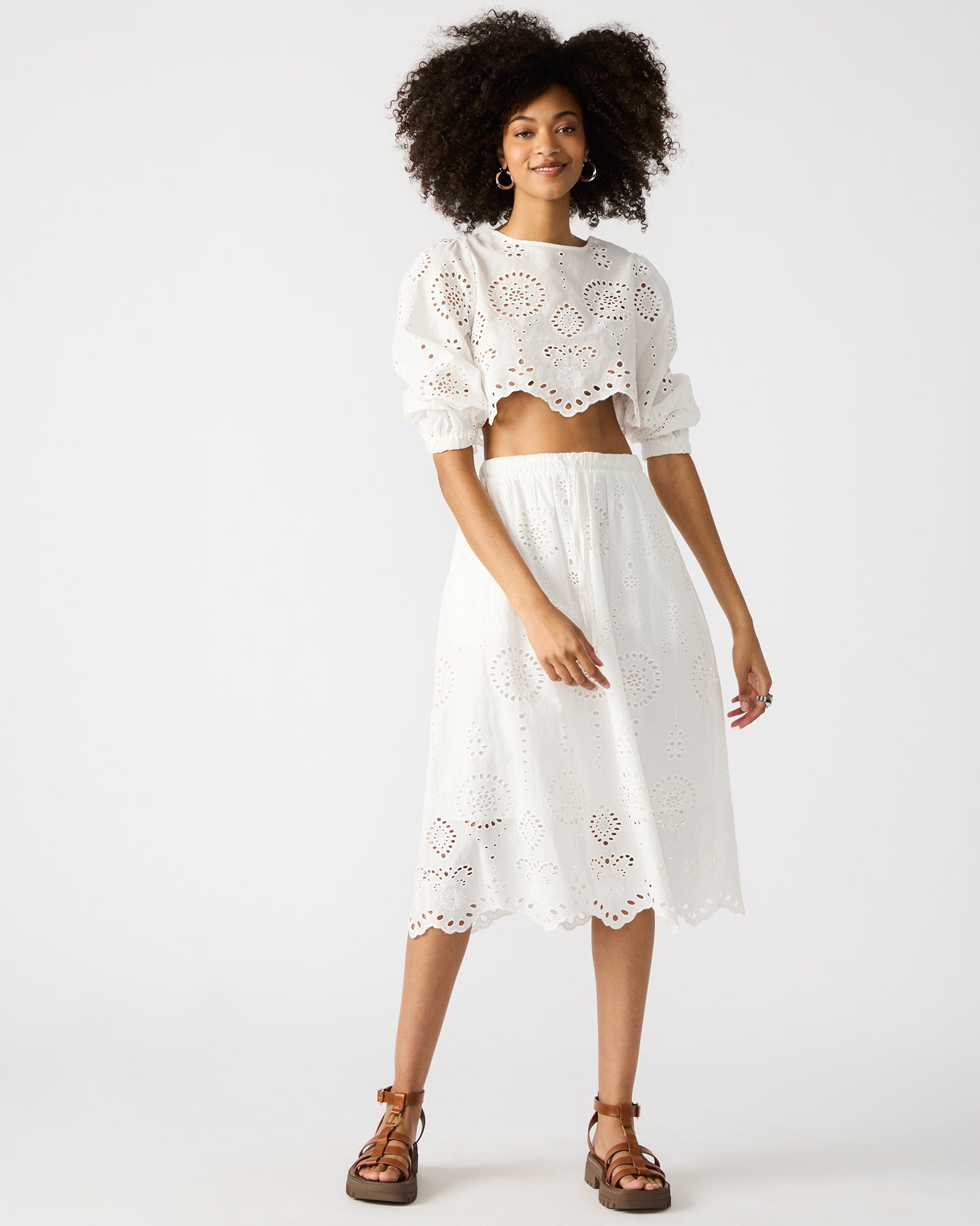 Model wearing the white crop top in a city setting, highlighting its versatility