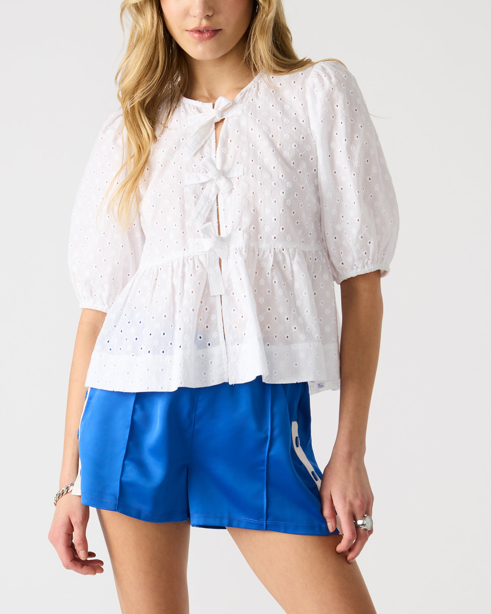 Model wearing the chic white puff sleeve top, paired with stylish denim for a casual look.