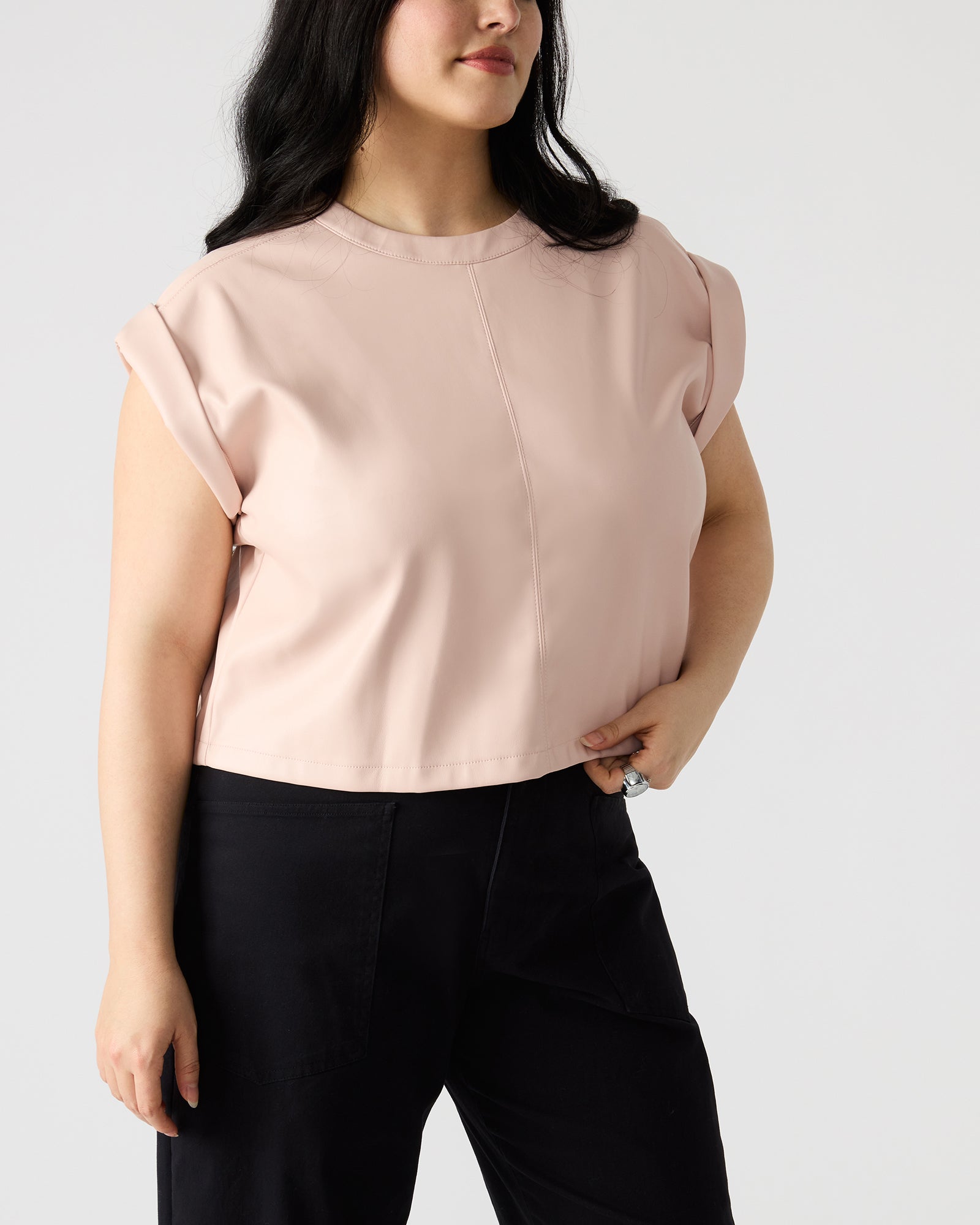Front view of chic faux leather zipper back top on model