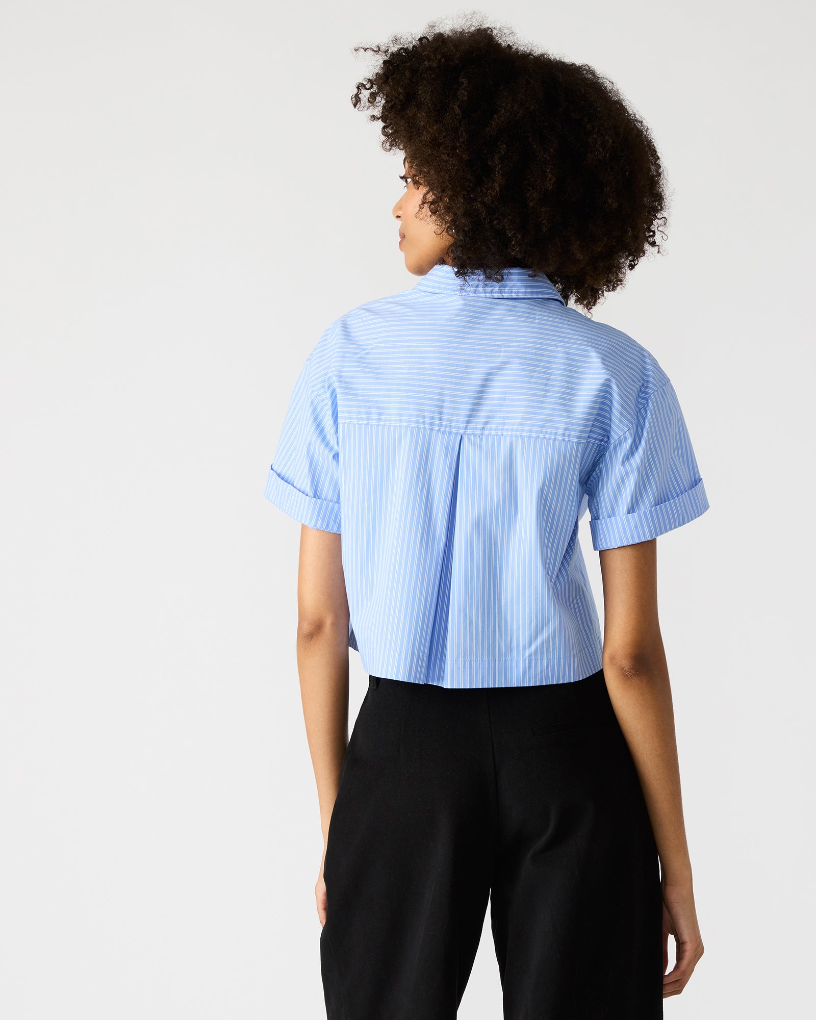 Tula striped blouse worn by a model in a casual urban setting
