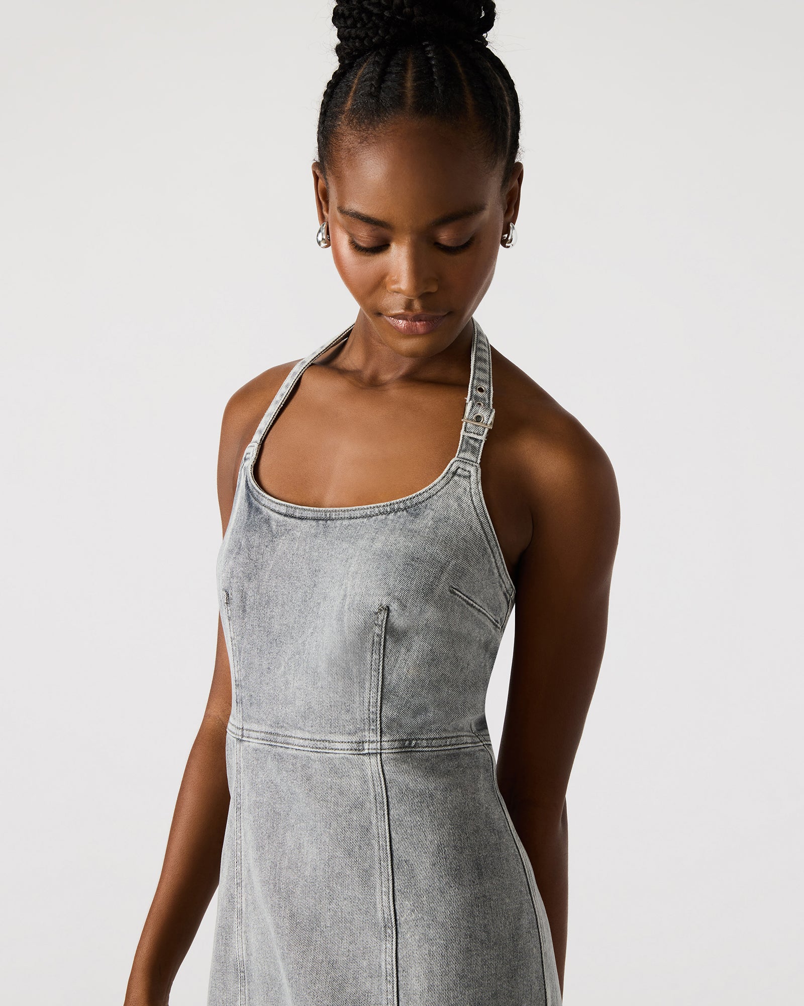 Front view of the light grey denim dress on a model, highlighting the midi length