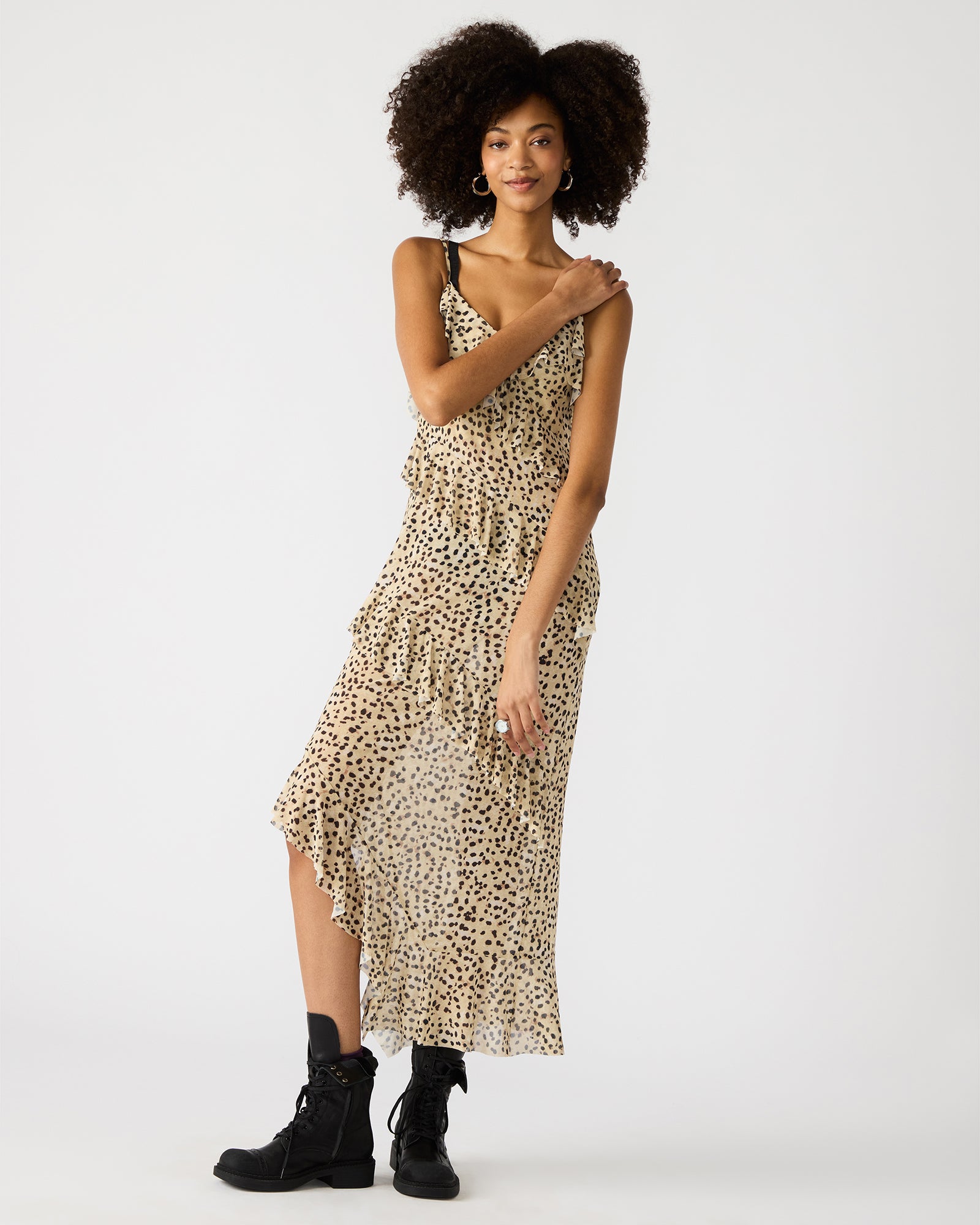 AIDA dress showing flowy ruffle design in a sunny garden setting.