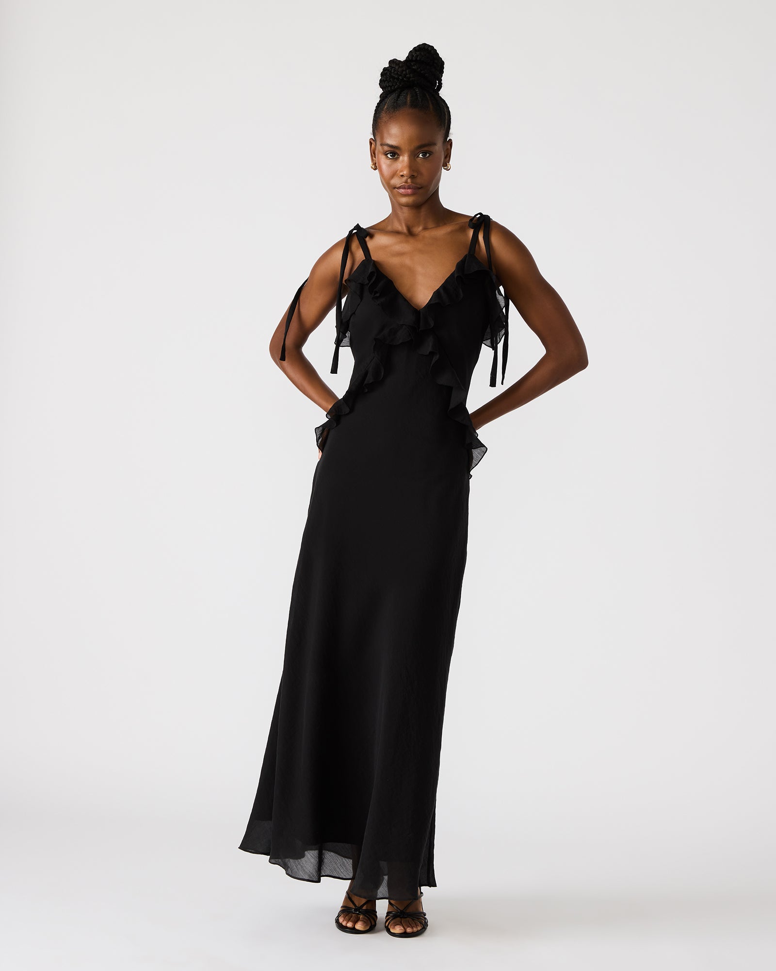 Close-up of black maxi dress ruffle detail neckline, suited for evening parties