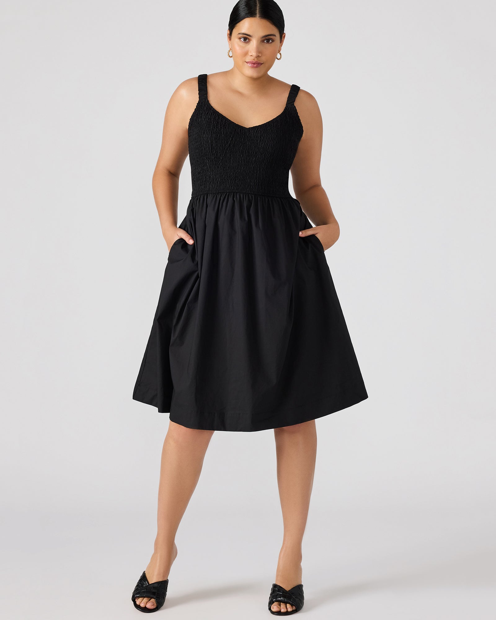 Black cotton midi dress draped elegantly on a model, showcasing smocked detail