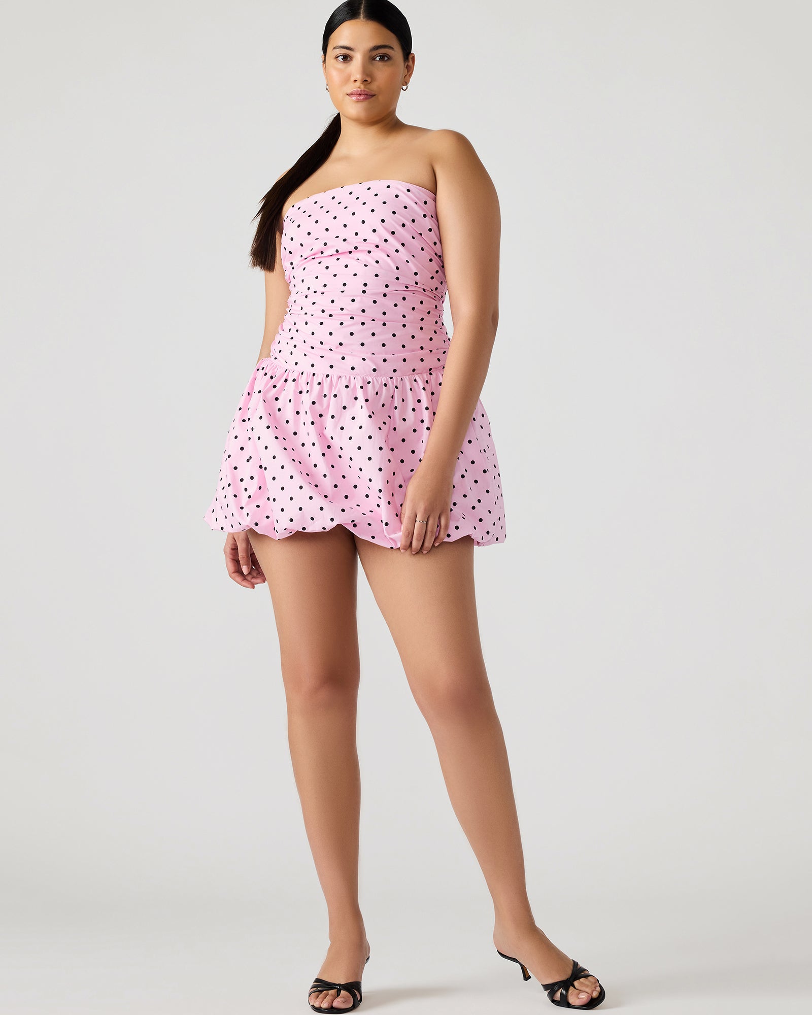 Front view of pink strapless mini dress with bubble skirt worn at a rooftop party.