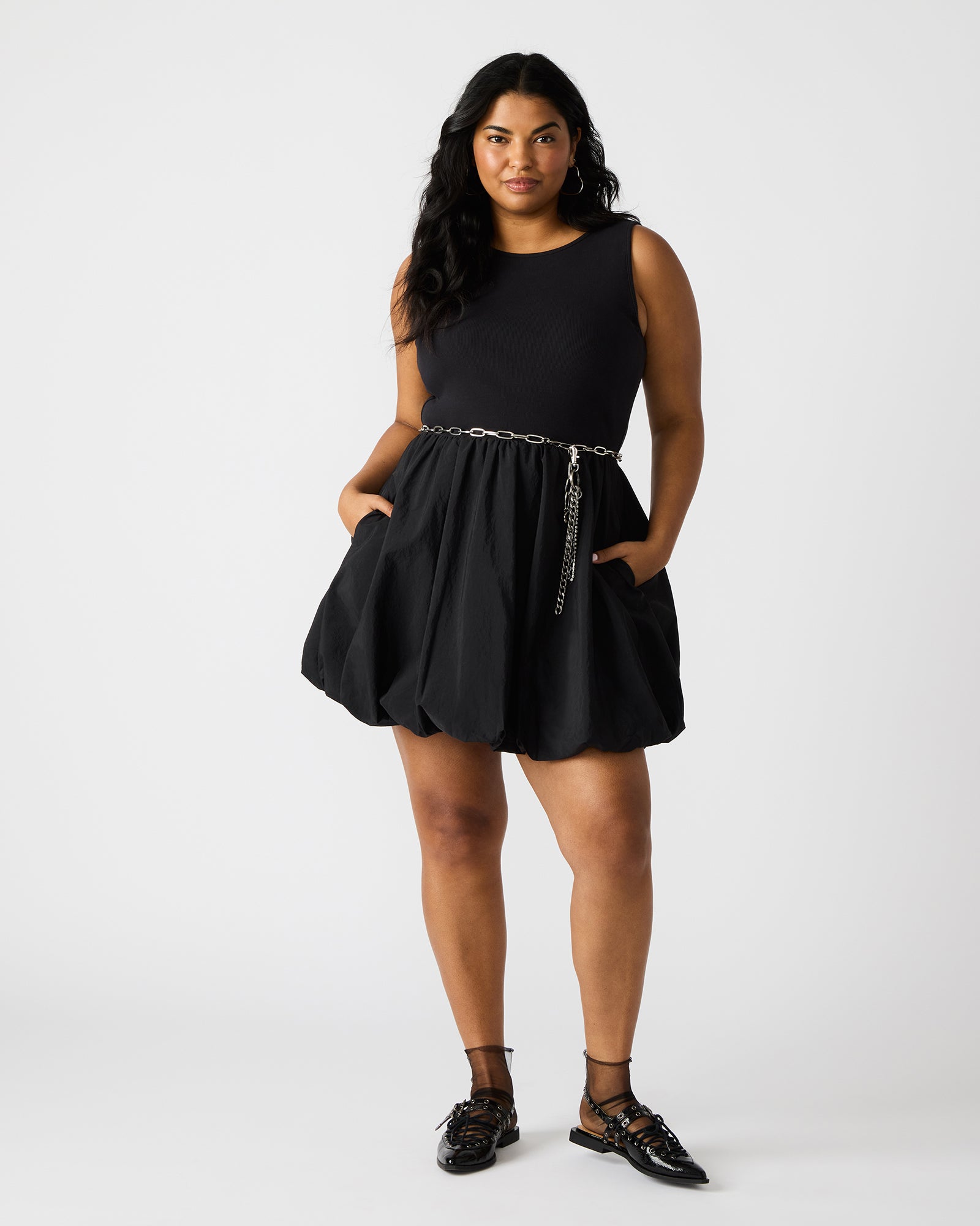 View of the black long sleeve mini dress showcasing its bubble hem design.