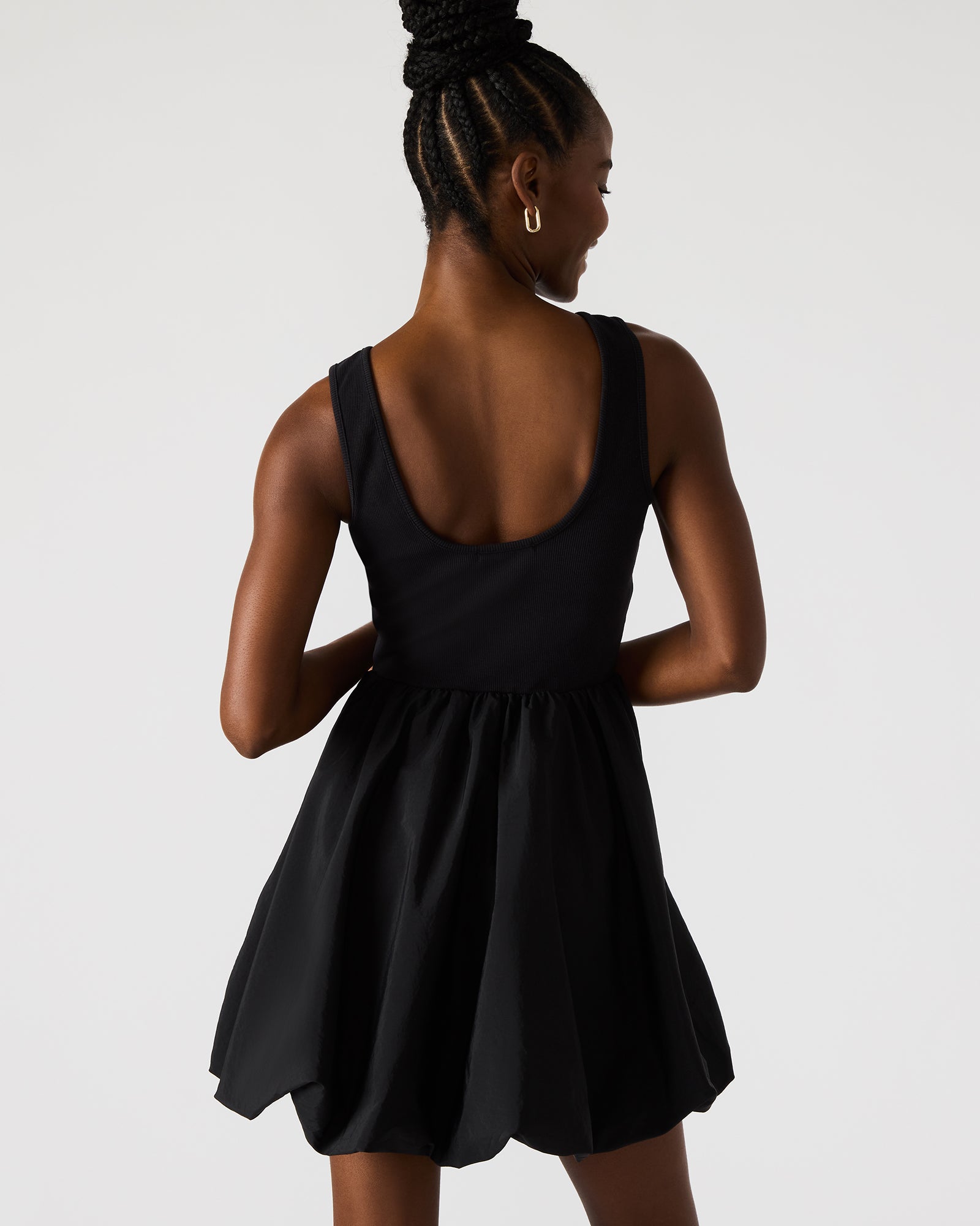 View of the black long sleeve mini dress showcasing its bubble hem design.