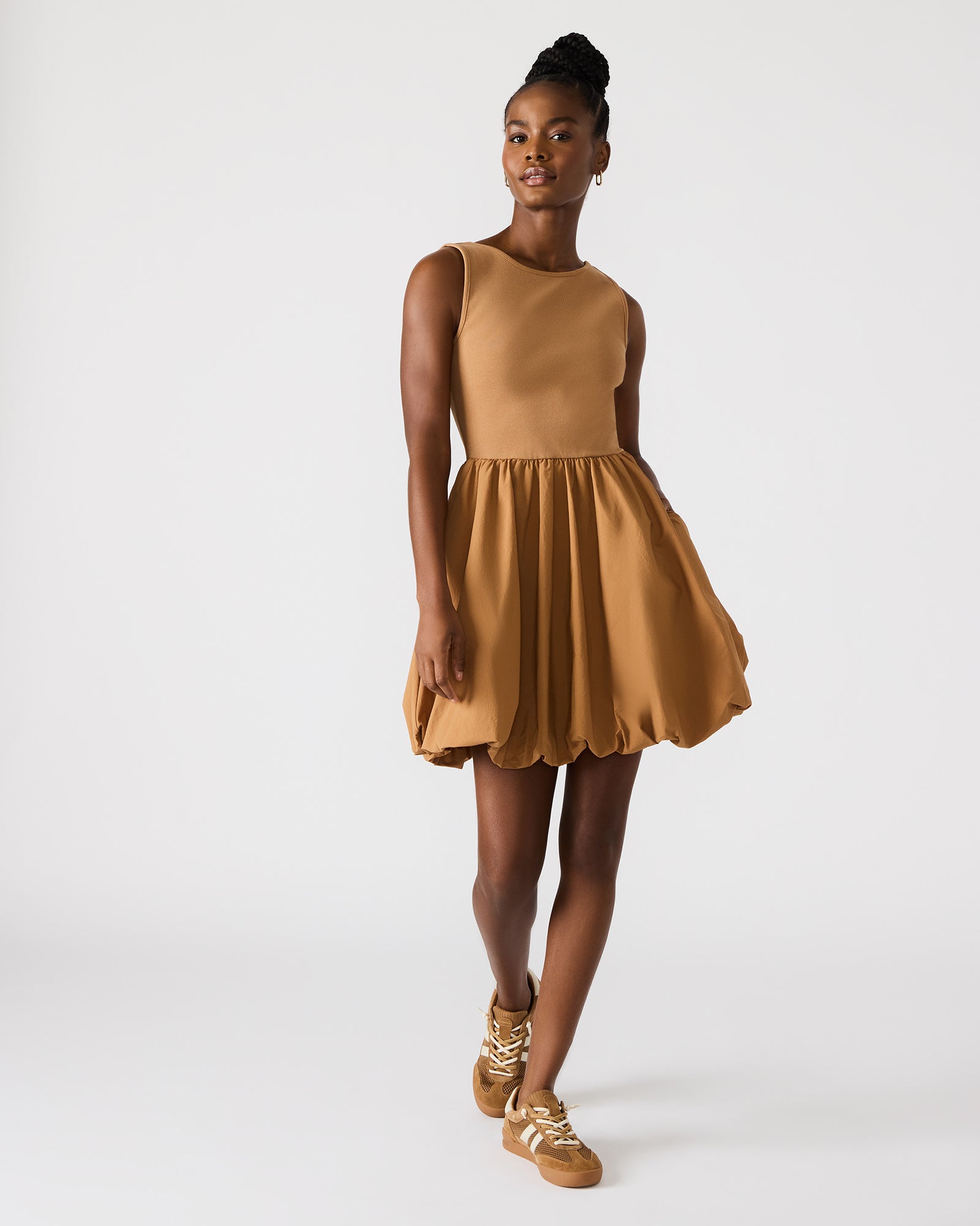 Front view showing sleeveless mini dress fit on a model outdoors