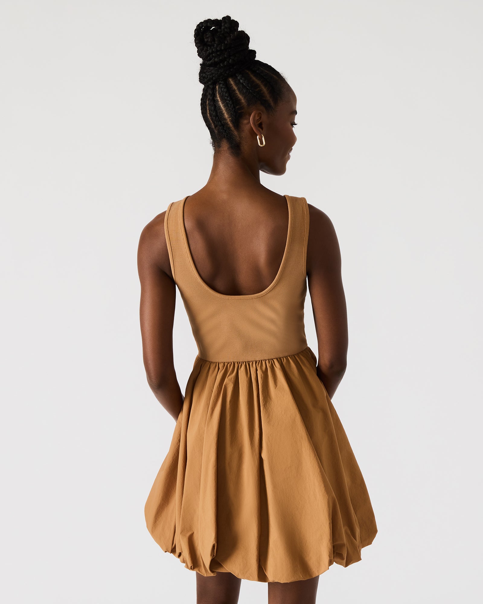 Close-up of bubble dress hem with soft pleating in caramel tone