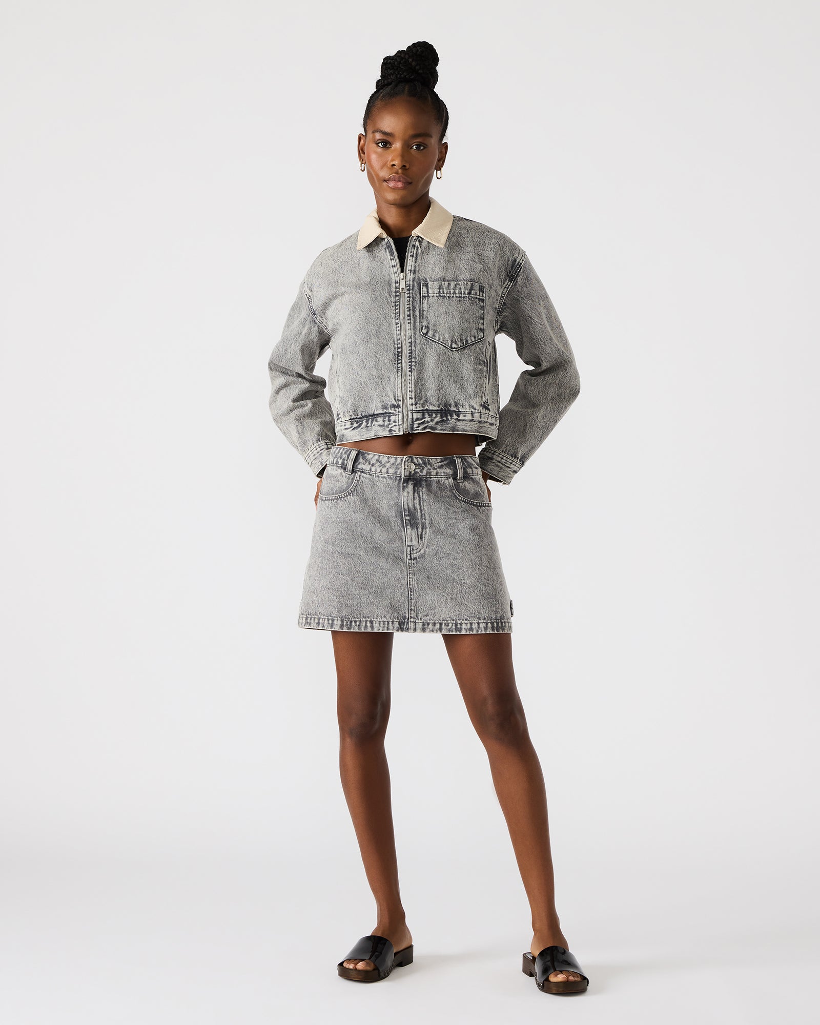 Front view of a woman in a light grey oversized denim jacket.