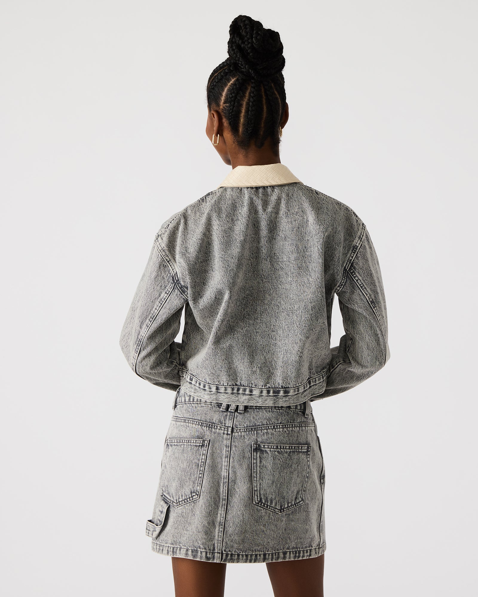 Close-up of the front zipper closure of the light grey denim jacket.