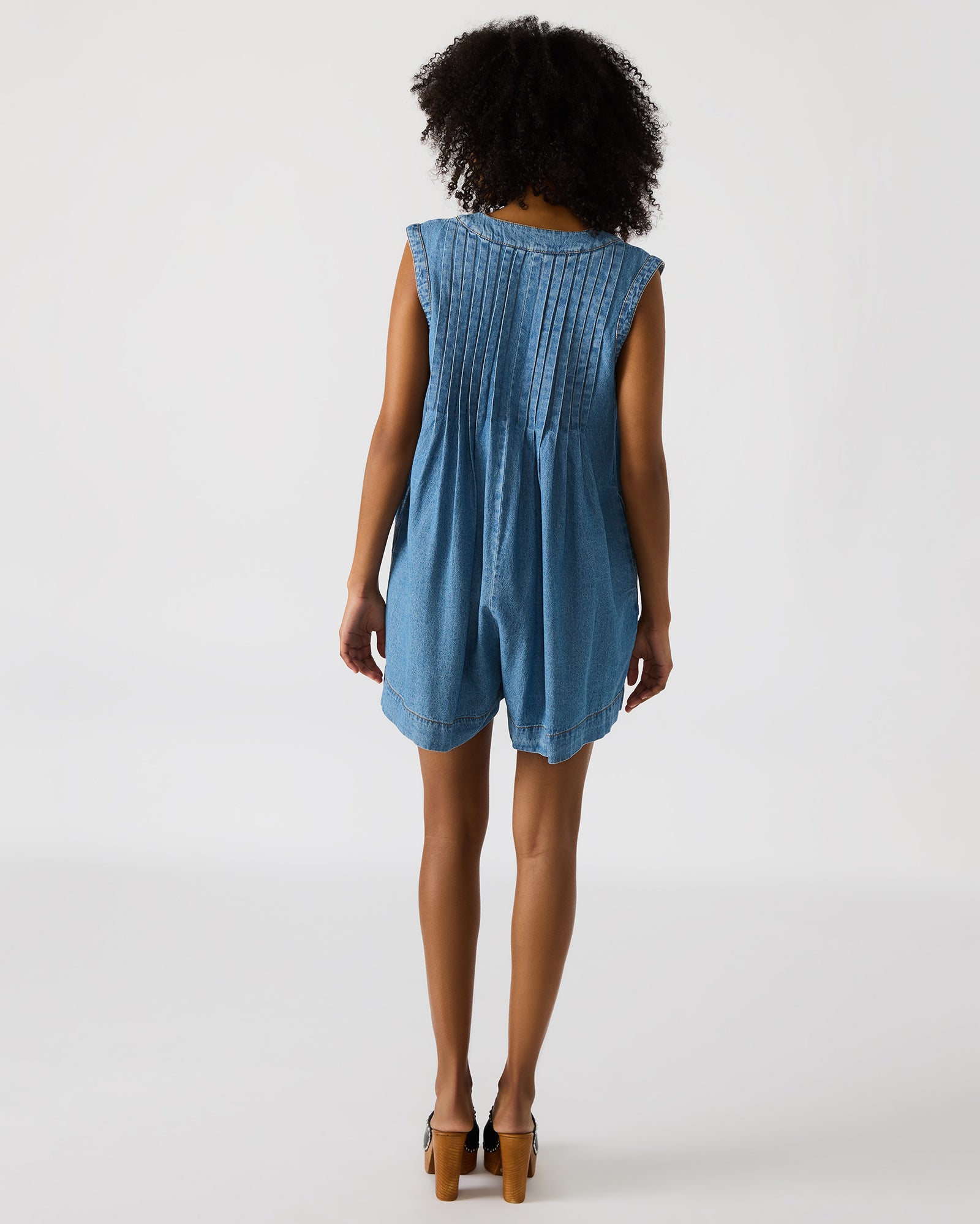 Front view of Mick denim romper shorts on a model, showcasing pocket details.
