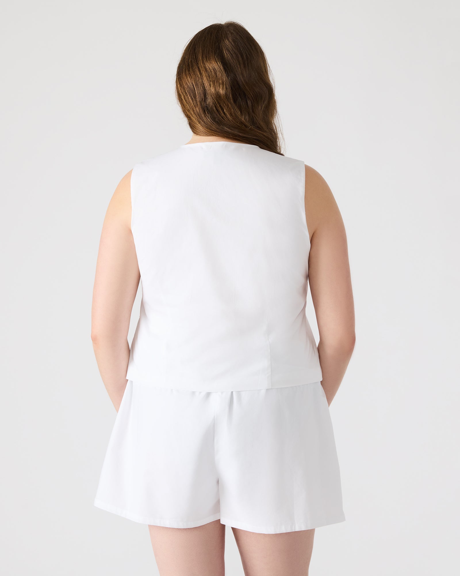 Aliza white tie-front top styled with high-waisted trousers for office wear