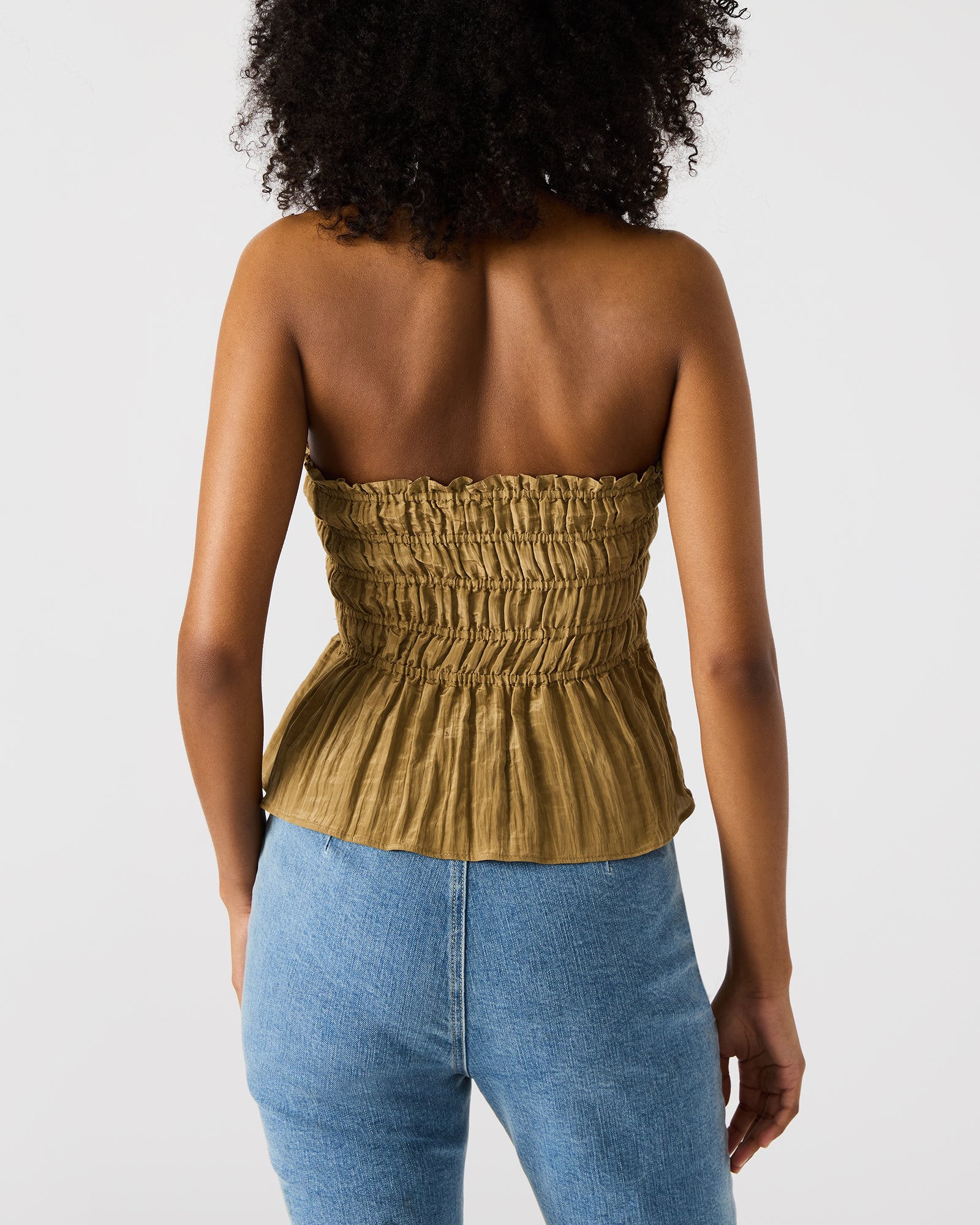 Model wearing the olive peplum blouse paired with accessories for a night out