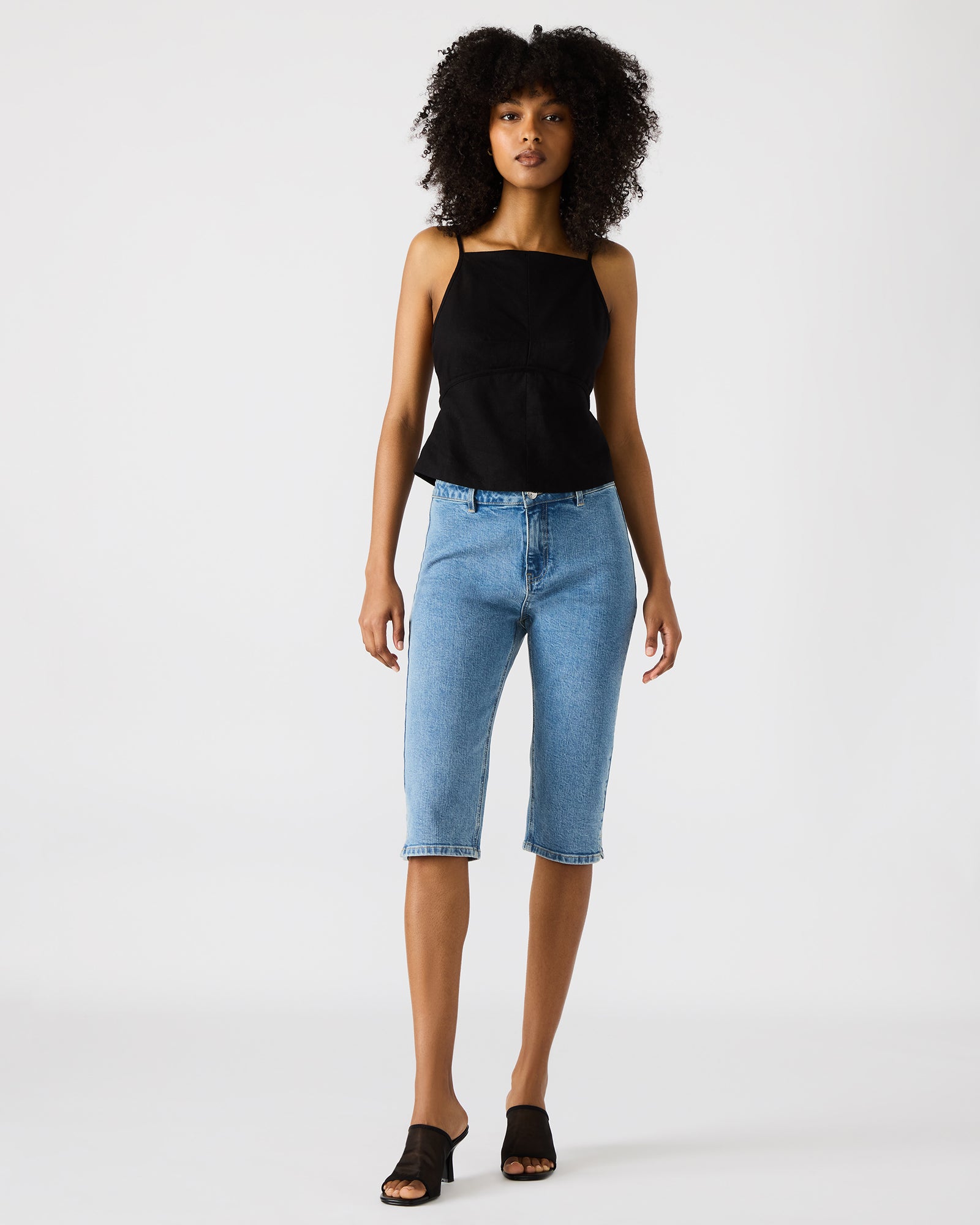 Close-up of the Tiegan black top’s square neckline and strap details