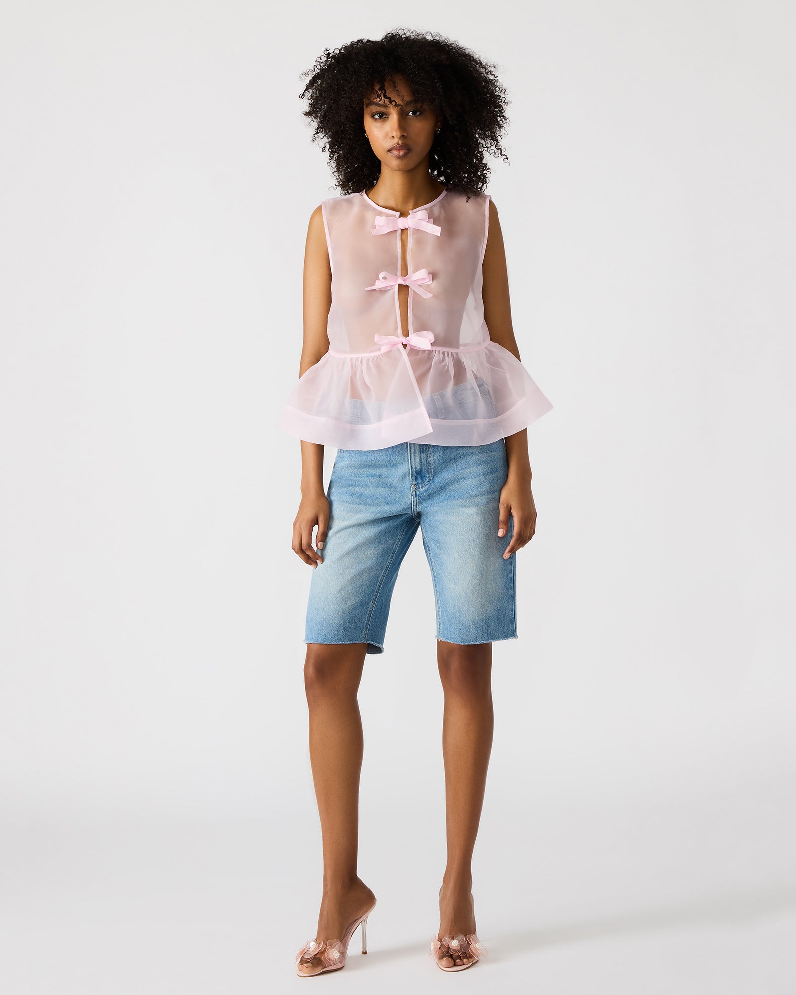 Side profile of lightweight sheer black top in natural light