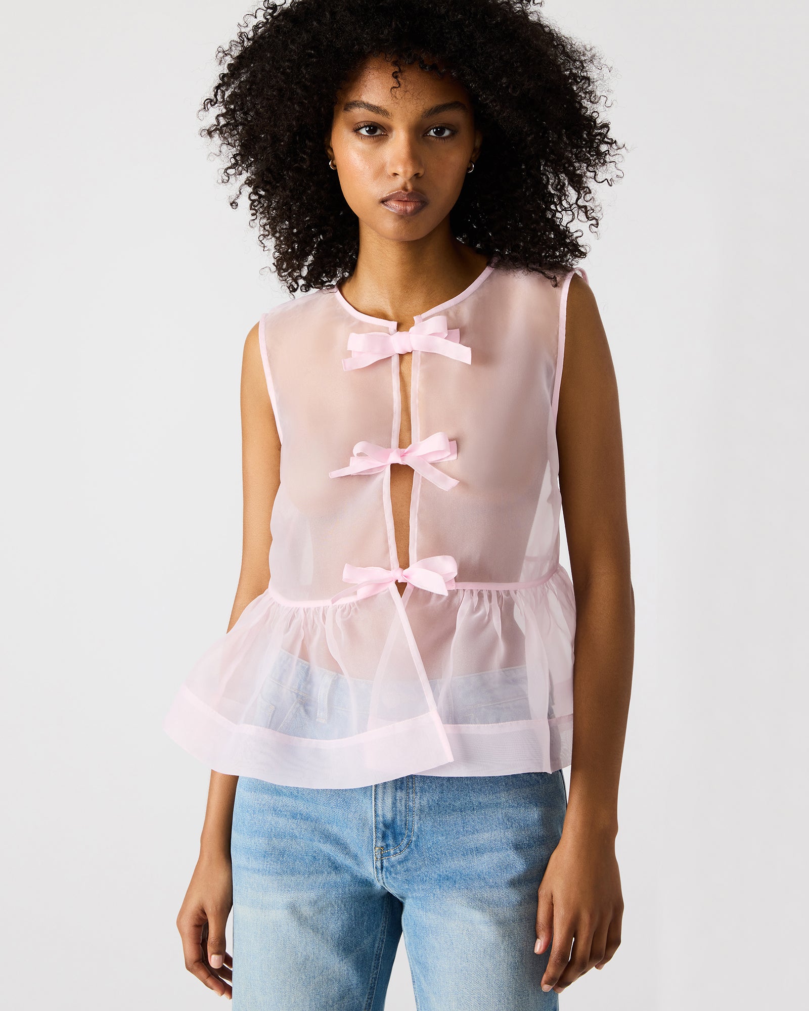 Front view of sheer blush top styled for spring outings