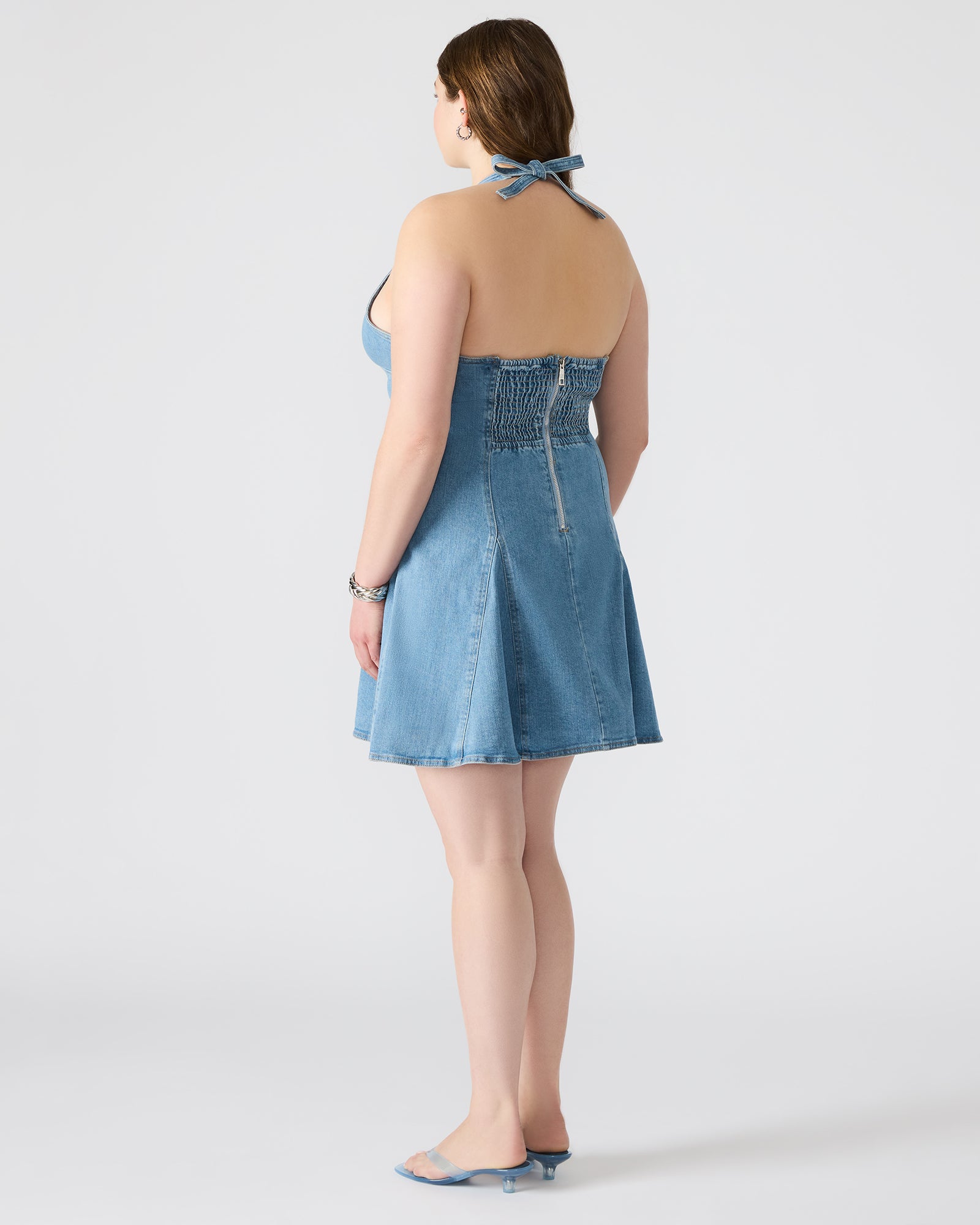 Malia denim dress on a model in a sunny park setting.