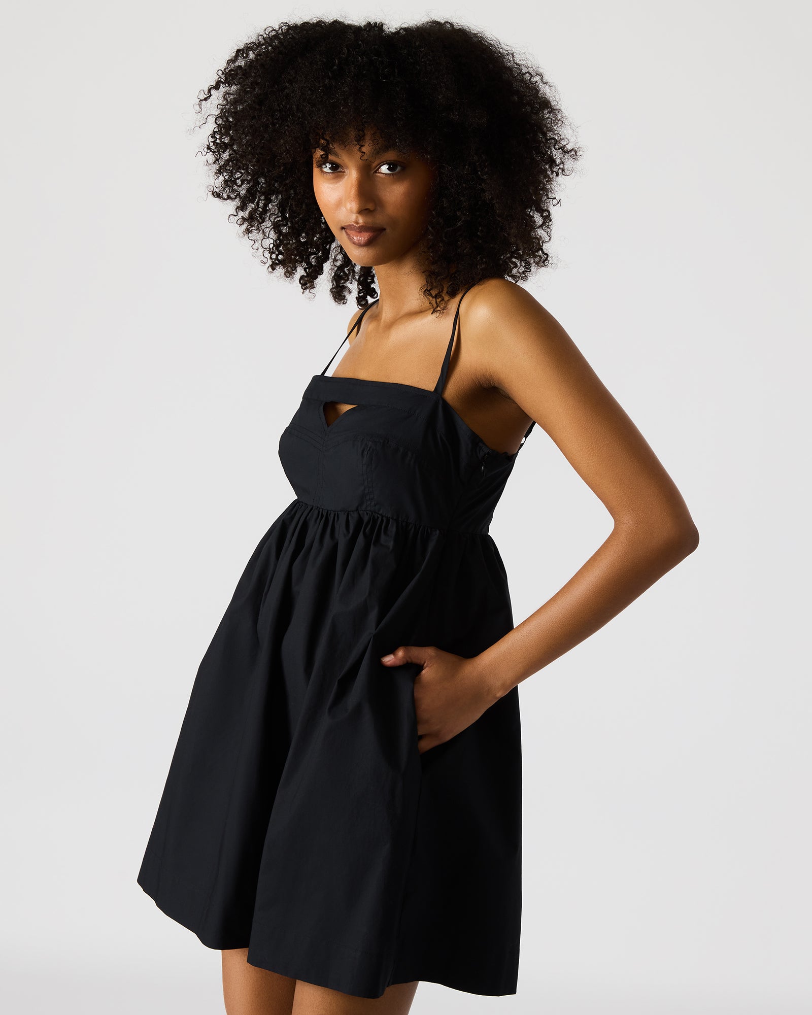 Side angle showing adjustable straps and flowy skirt of the black dress