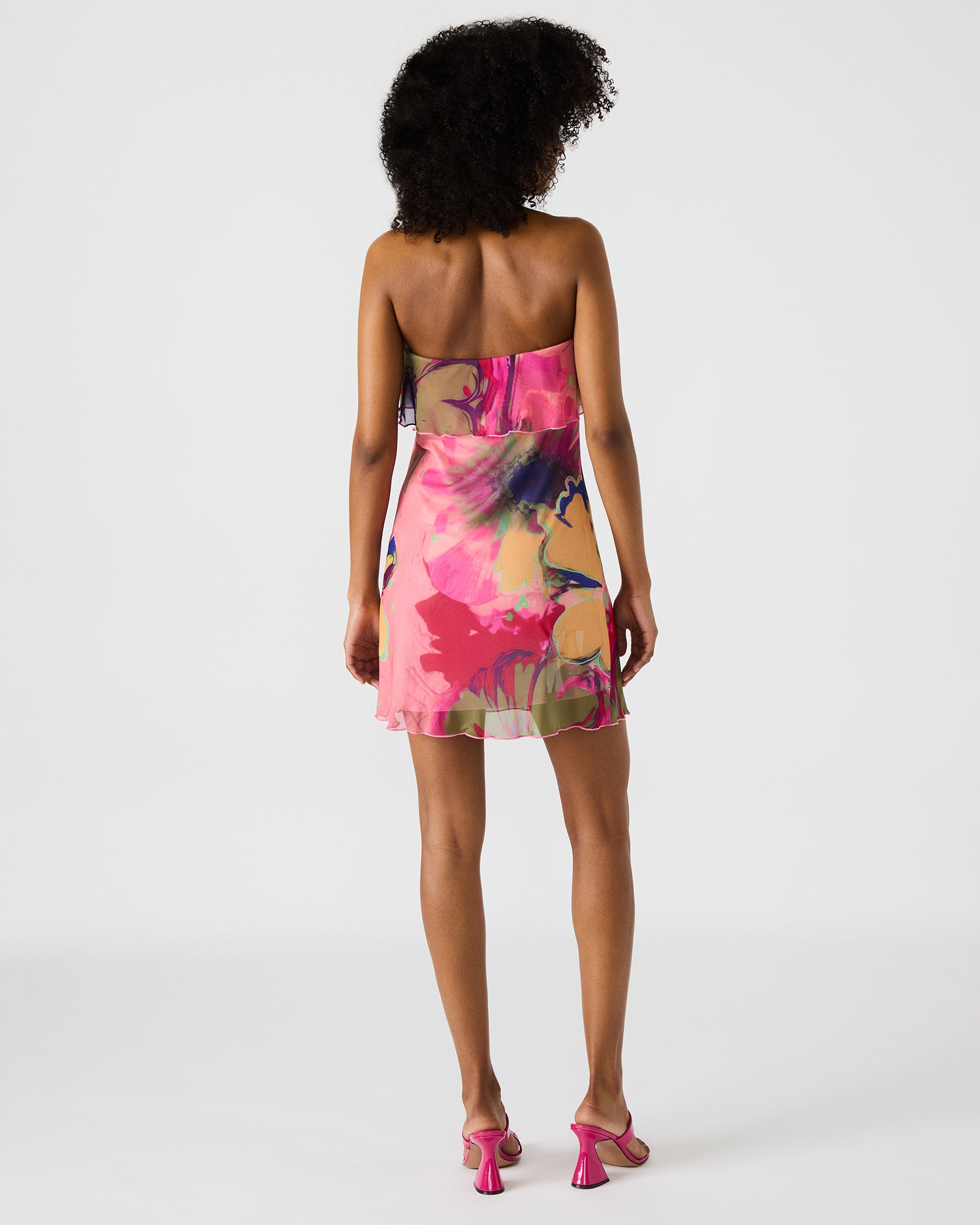 Model wearing blue floral strapless mini dress in sunlight
