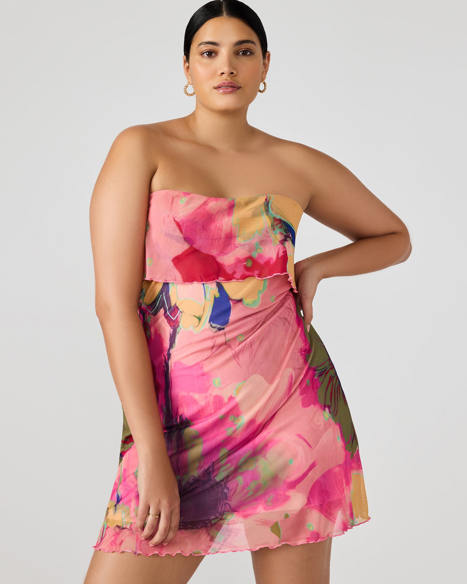 Model wearing blue floral strapless mini dress in sunlight
