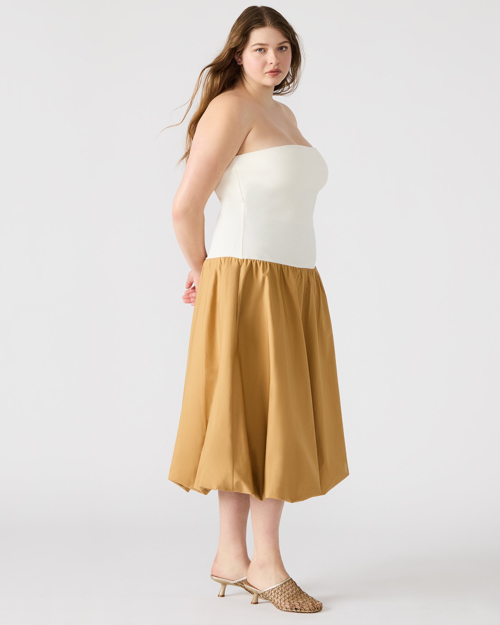 Side view of the chic strapless dress highlighting the bubble skirt