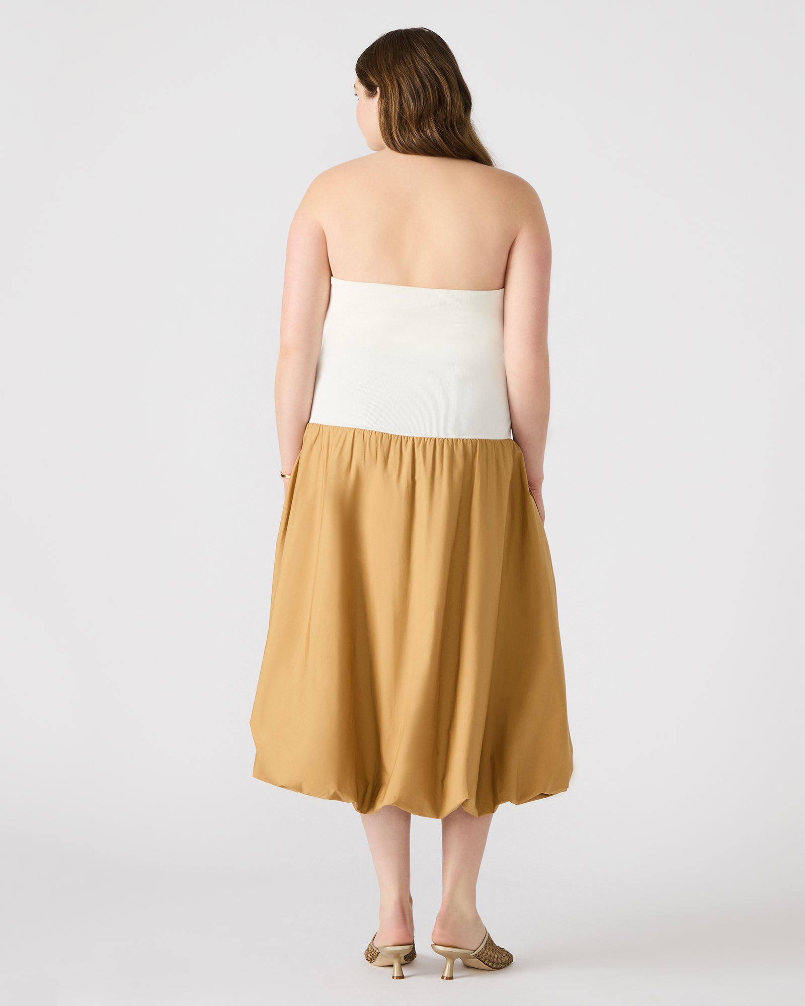 Front view of the taupe midi strapless dress on a model