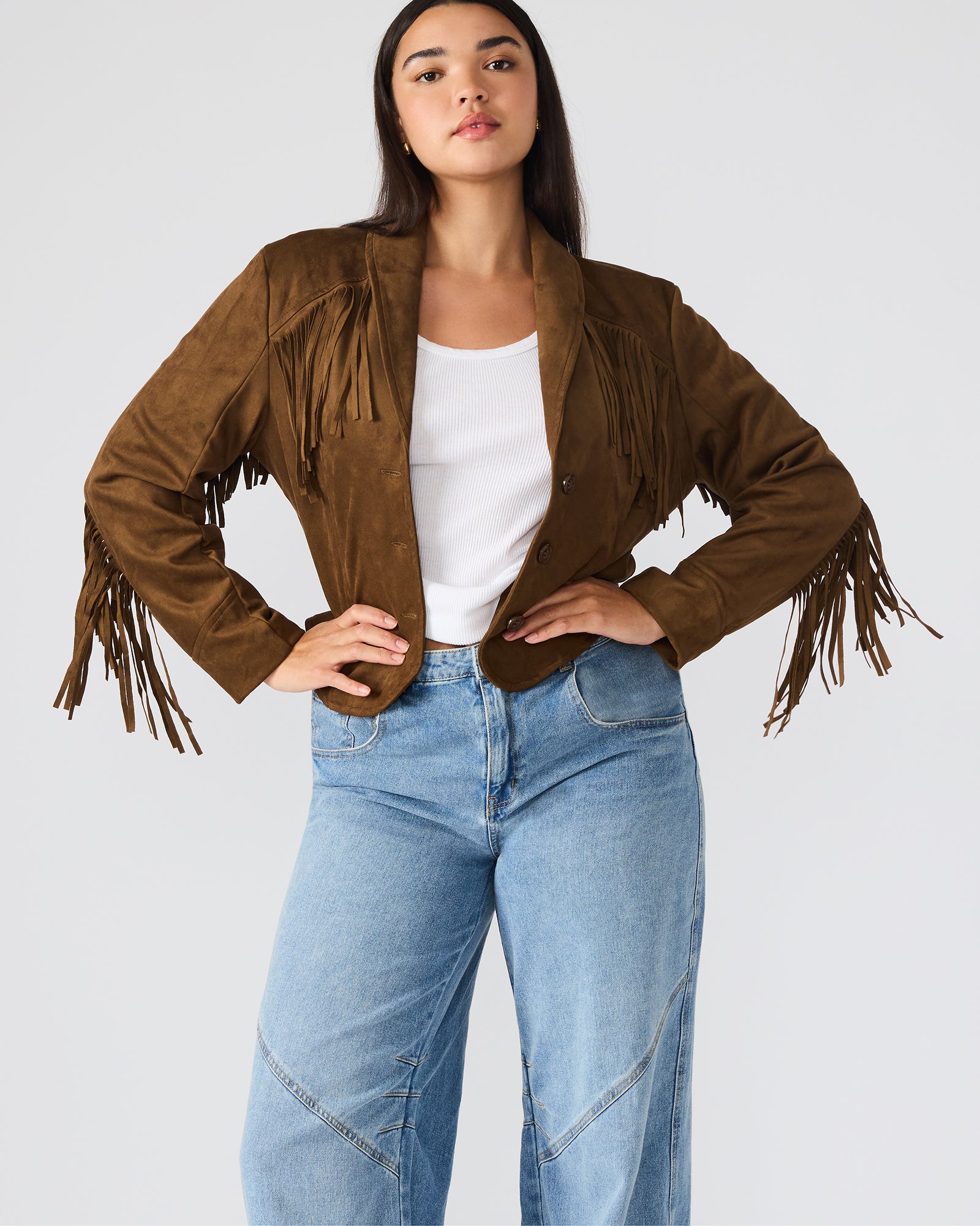 Model wearing a chestnut fringe jacket with western-inspired detailing, shot outdoors