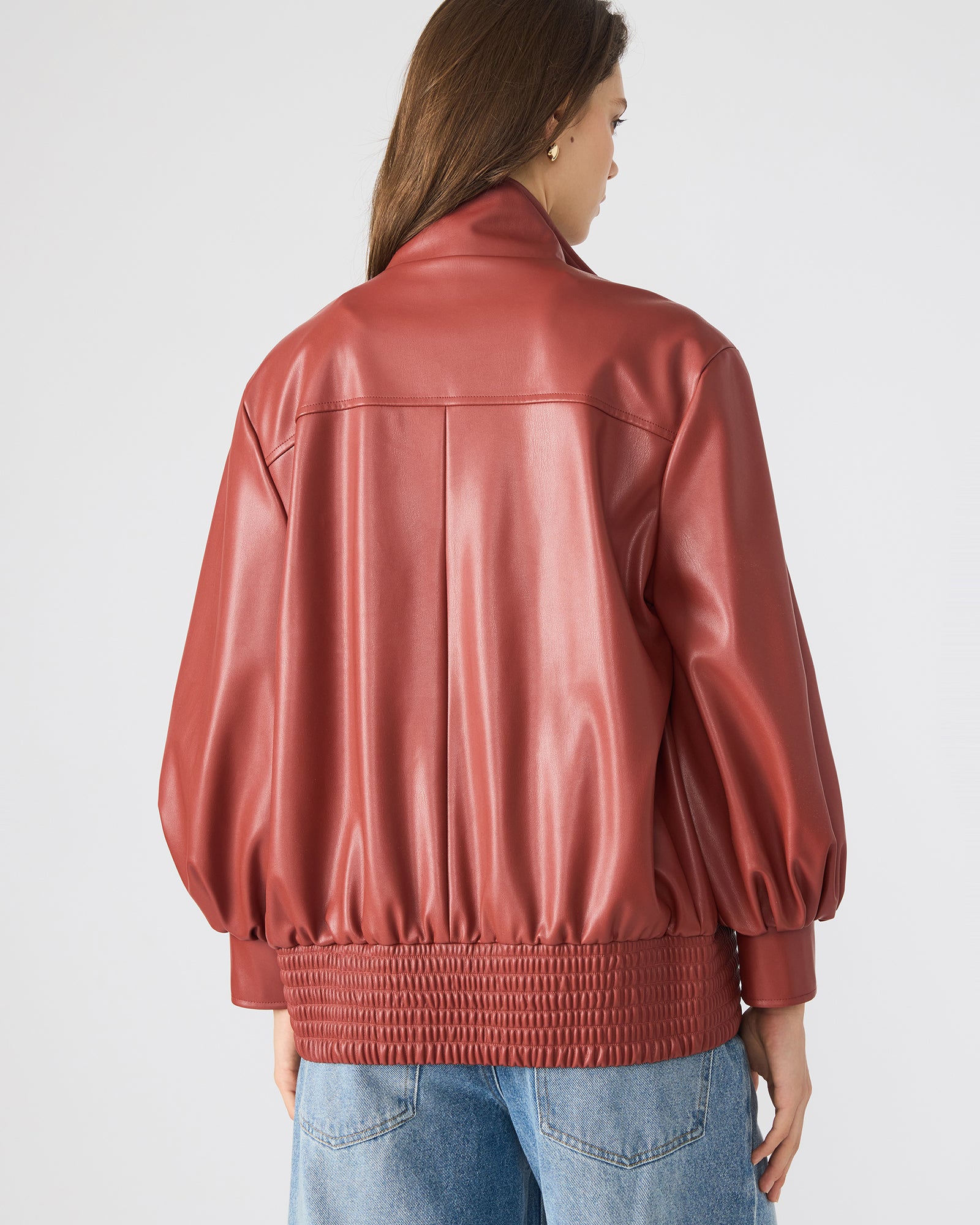 Model wearing the brown faux leather jacket in a casual outdoor setting.