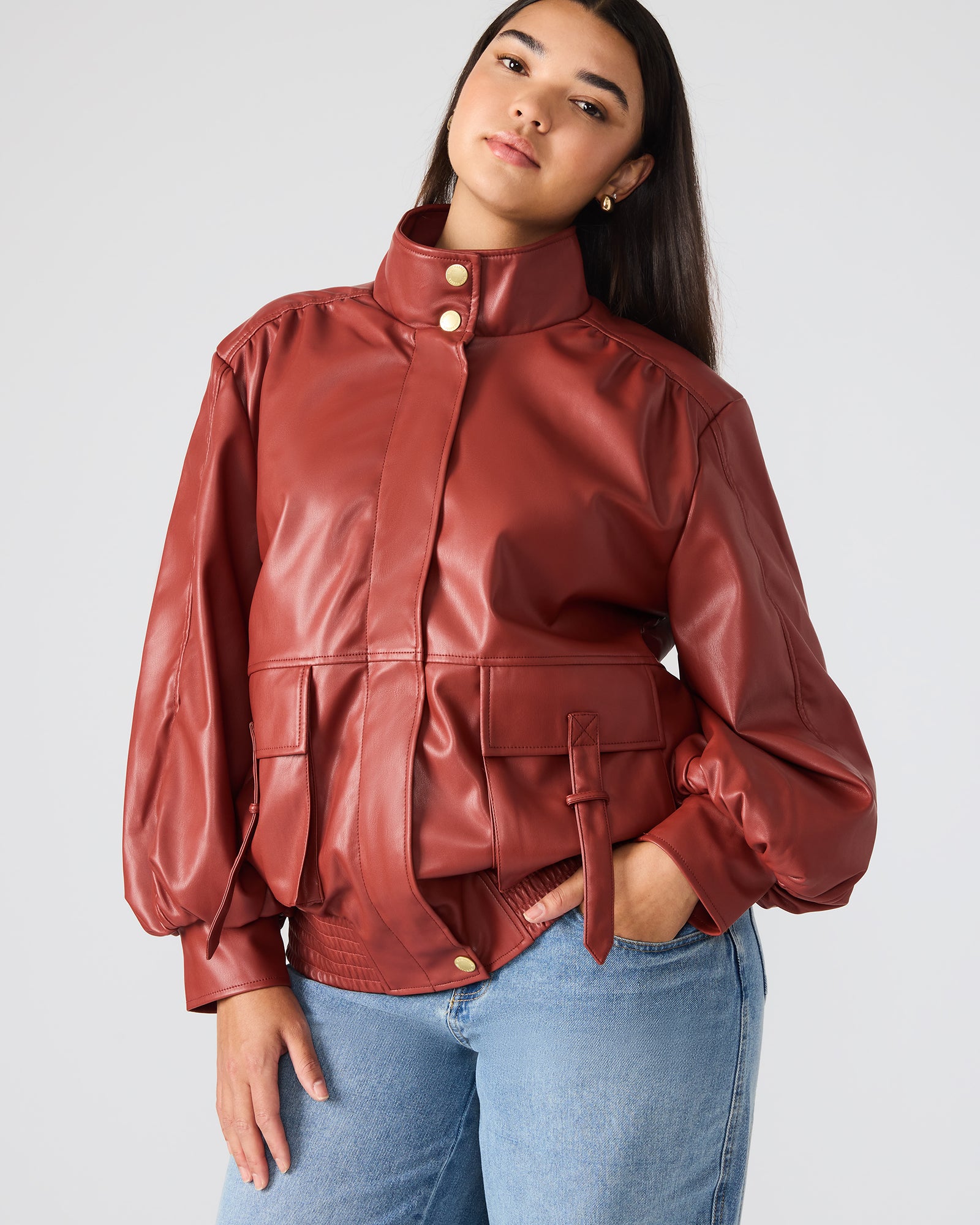 Model wearing the brown faux leather jacket in a casual outdoor setting.