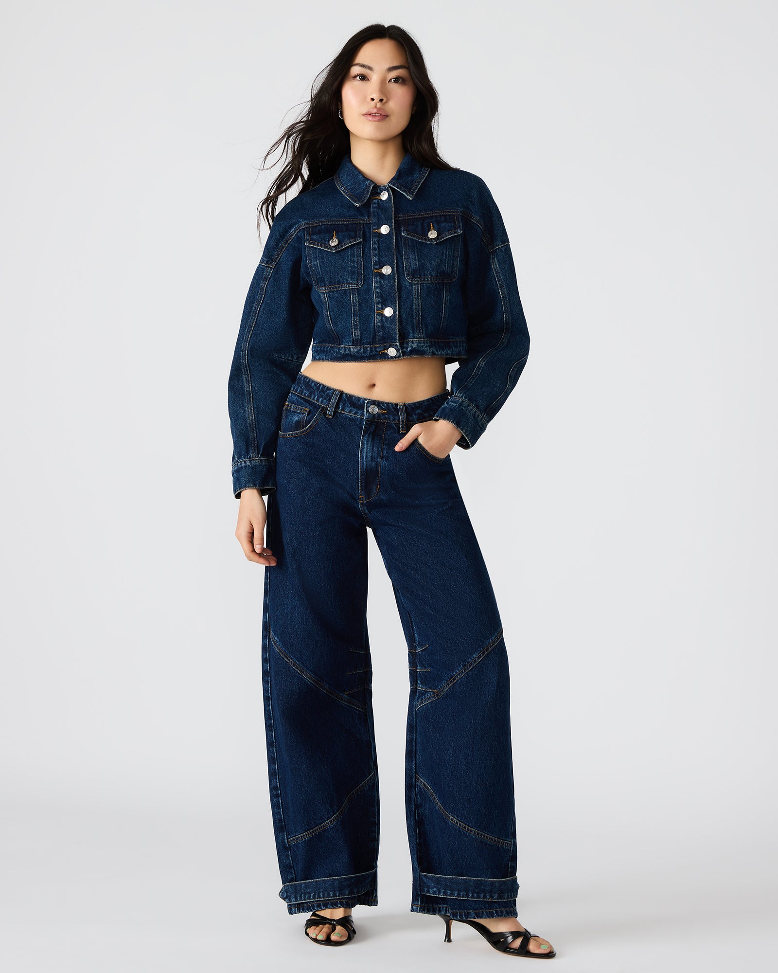 TRE dark wash baggy jeans on a hanger, highlighting the deep indigo color.
