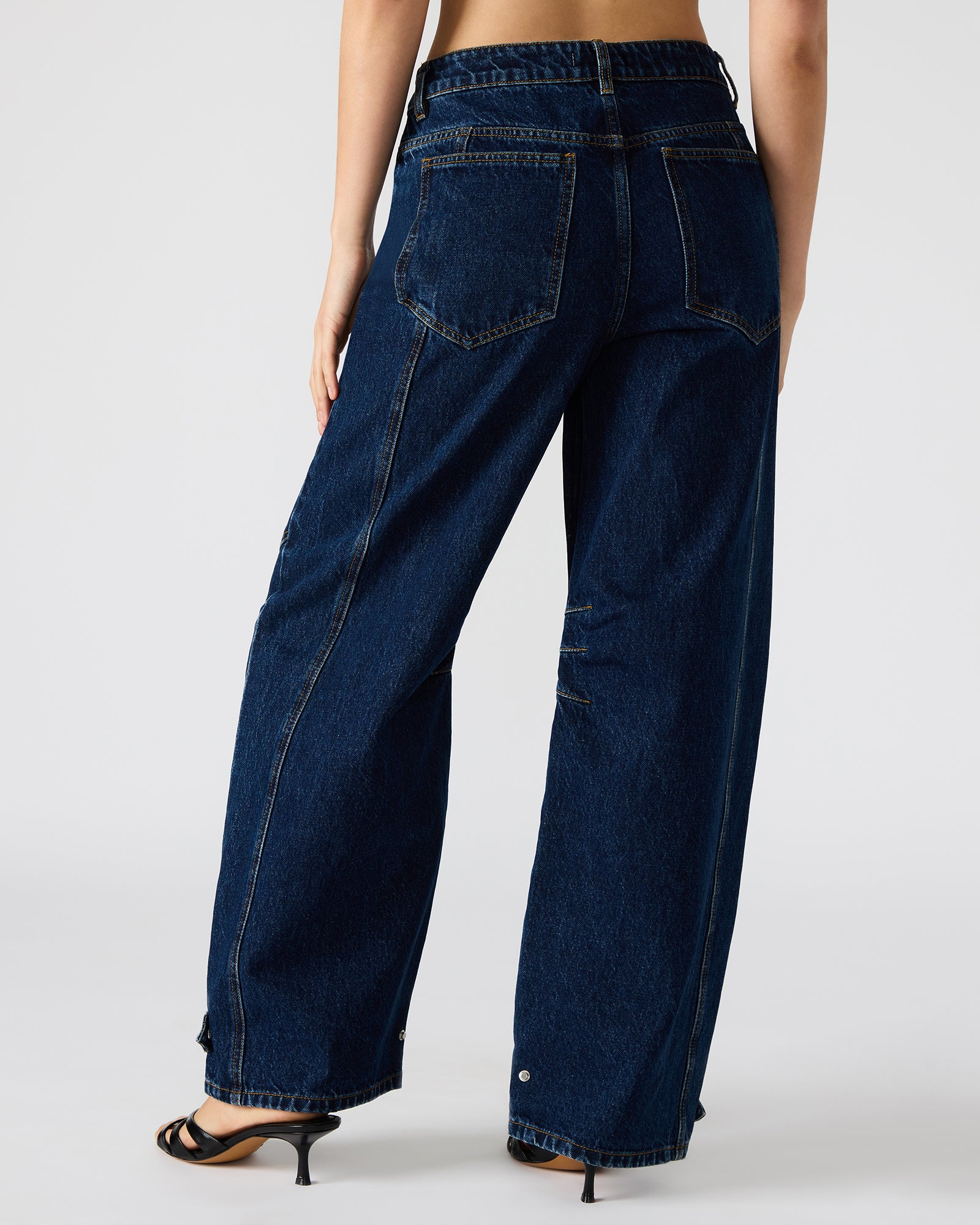TRE dark wash baggy jeans on a hanger, highlighting the deep indigo color.