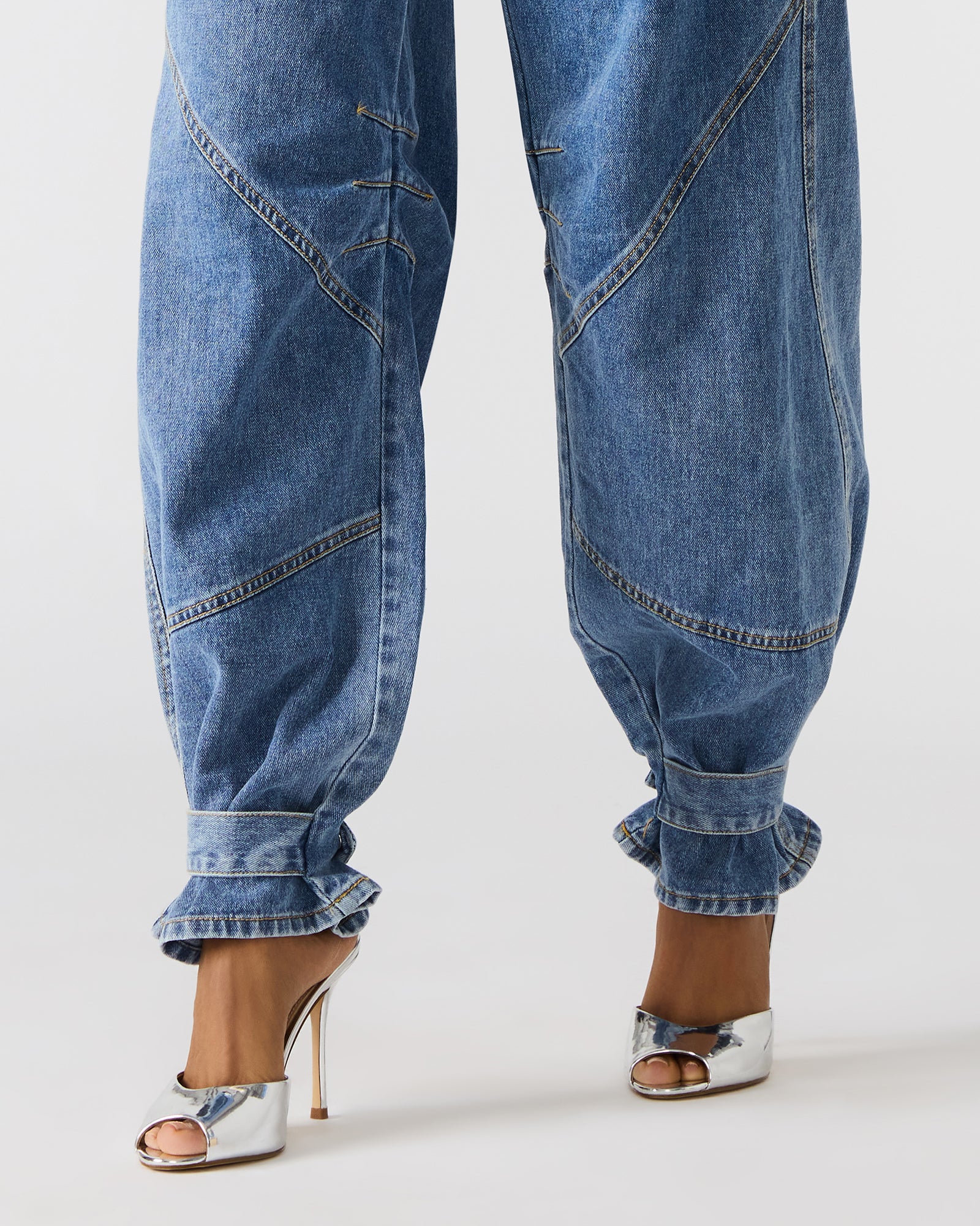 Detail shot of the button and zipper closure on Madewell barrel jeans.