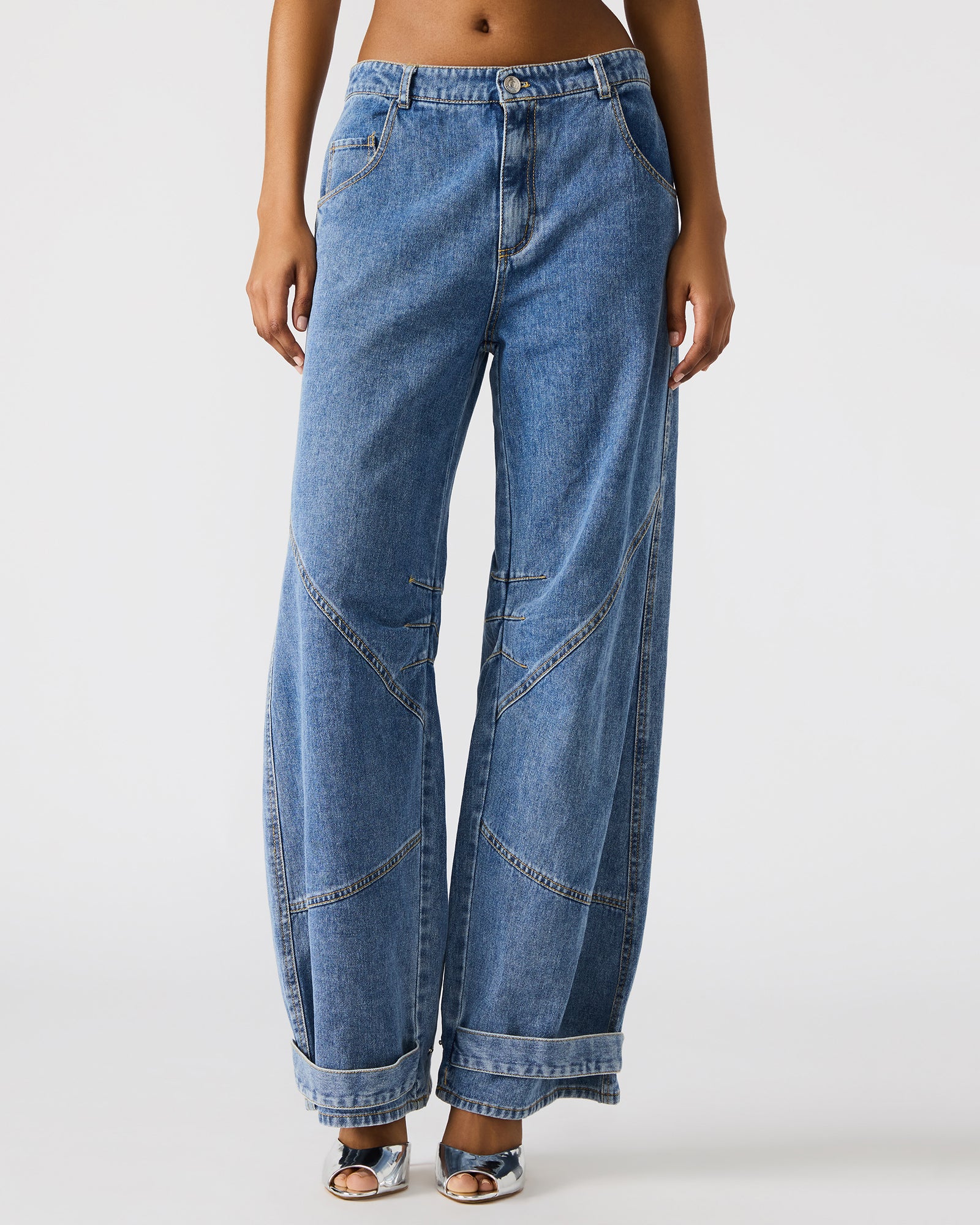 Detail shot of the button and zipper closure on Madewell barrel jeans.