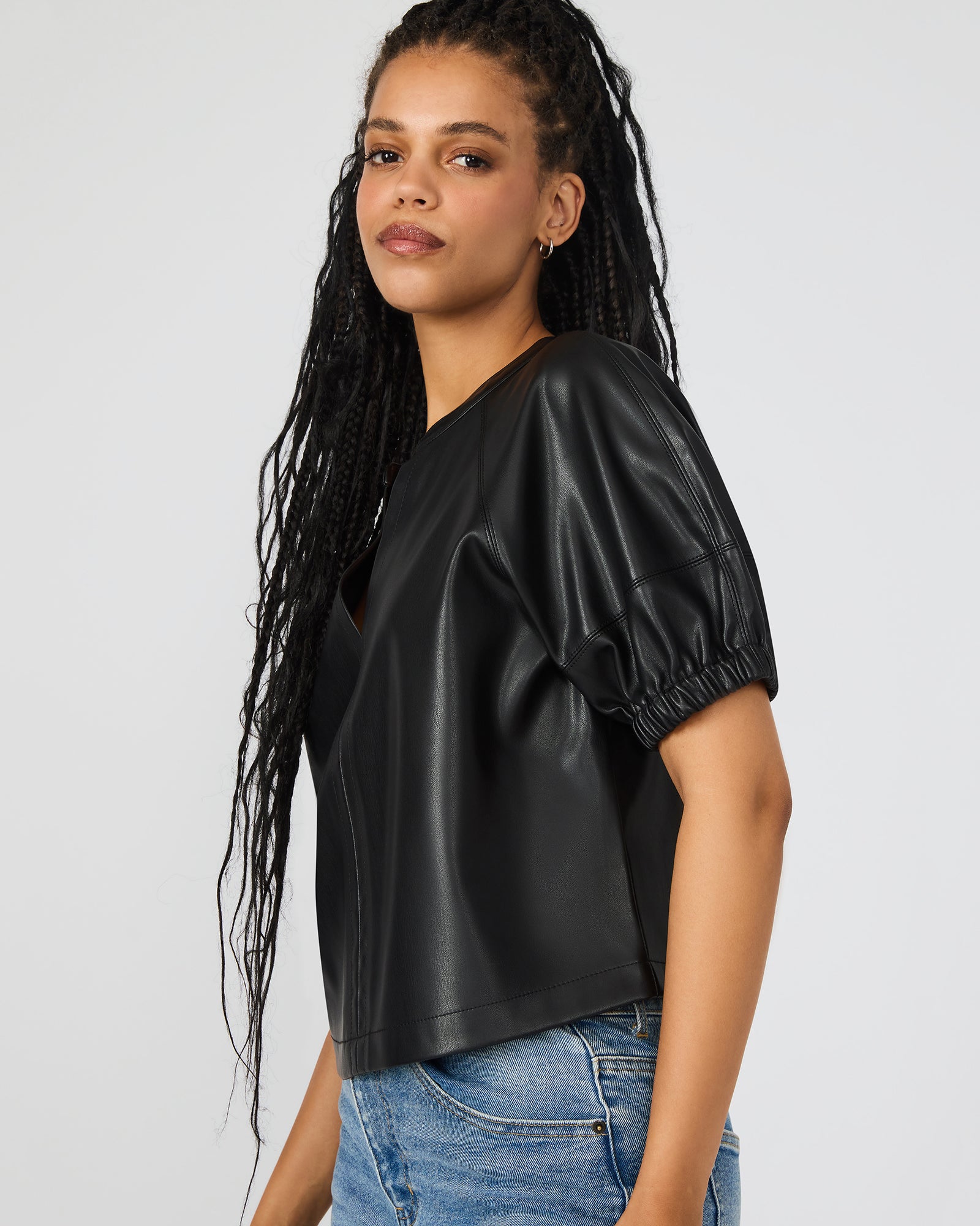 Side view showcasing the elegant silhouette of the black leather top.