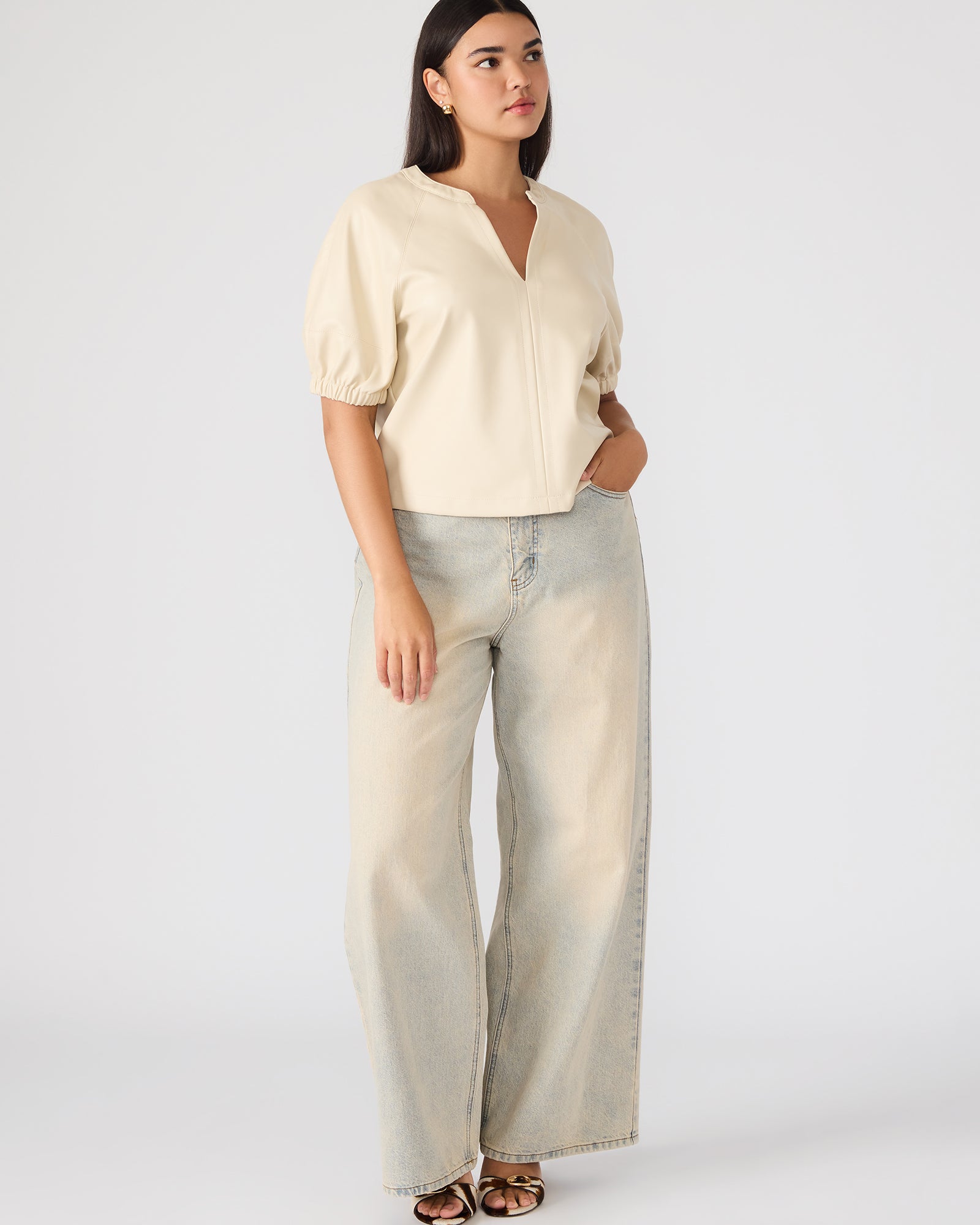 Close-up of faux leather texture and puff sleeve detail on blouse
