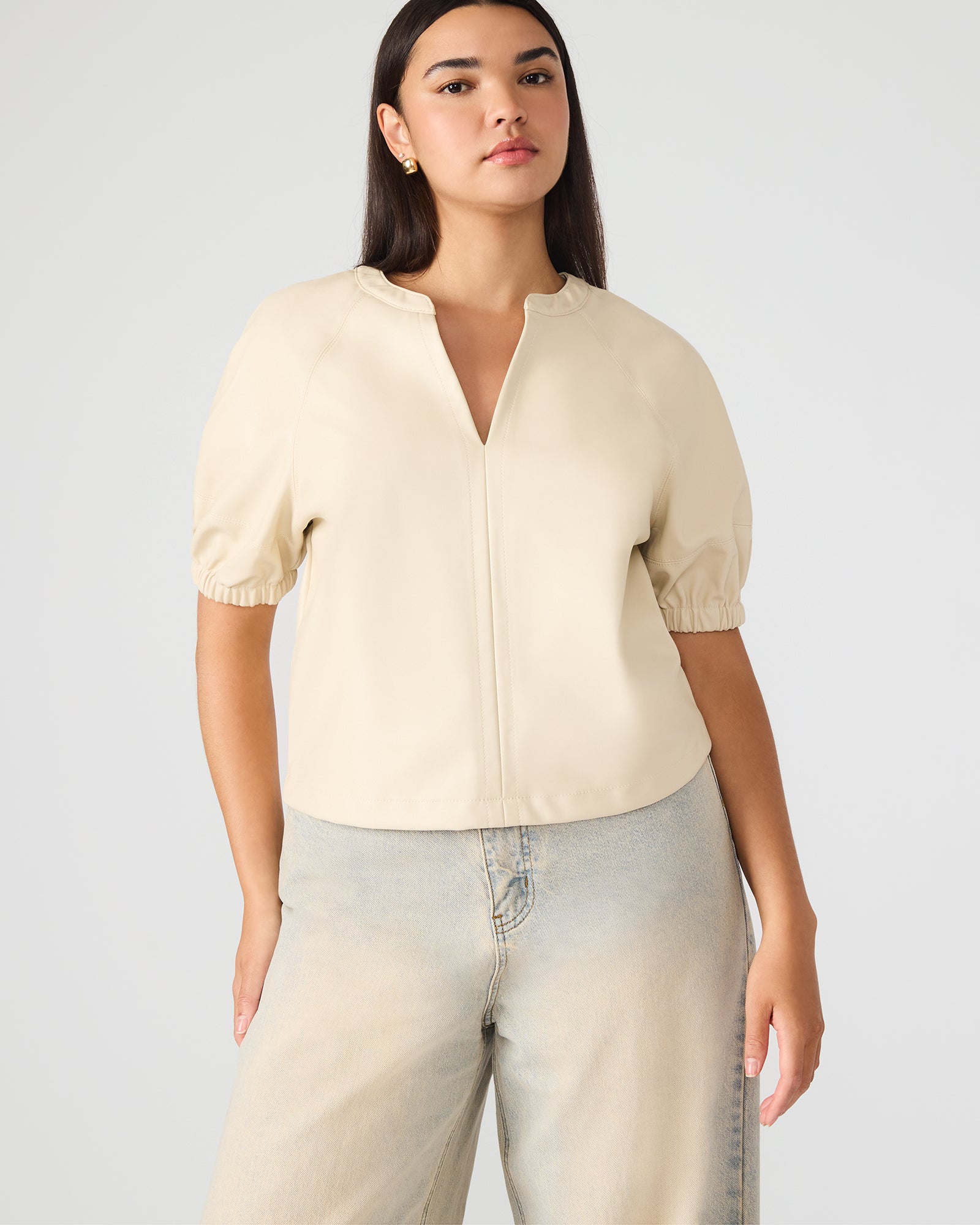 Close-up of faux leather texture and puff sleeve detail on blouse