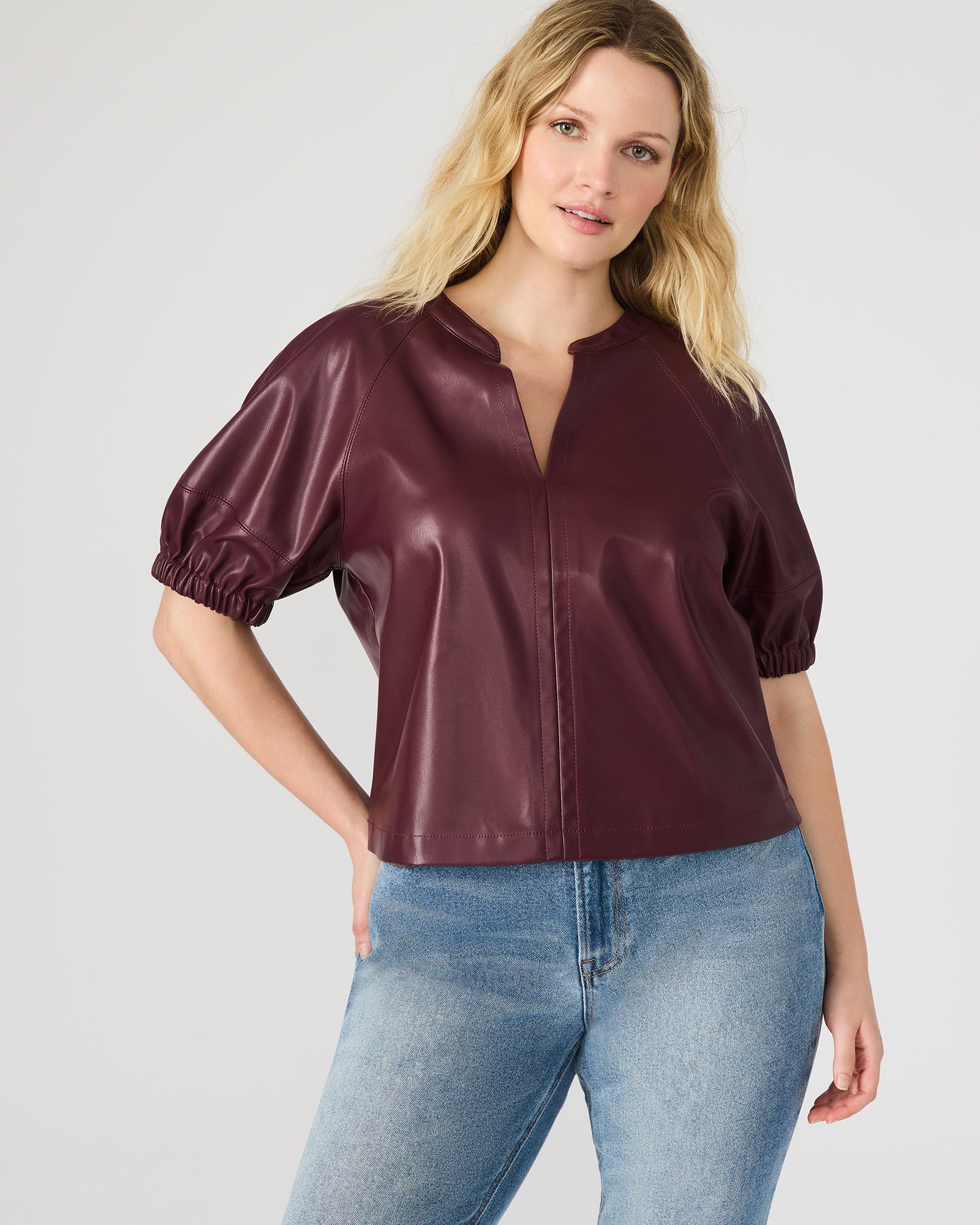 Close-up of the faux leather material on the puff sleeve top, emphasizing its luxurious texture