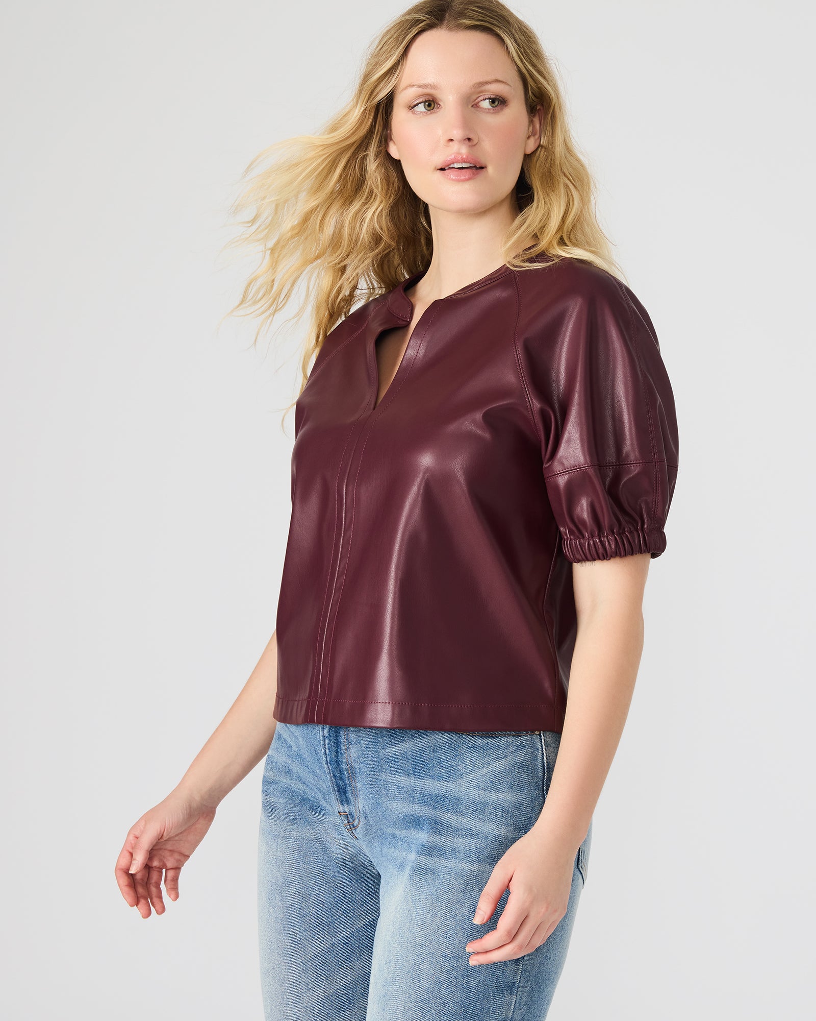 Model showcasing the faux leather puff sleeve top with off-the-shoulder style for a trendy look